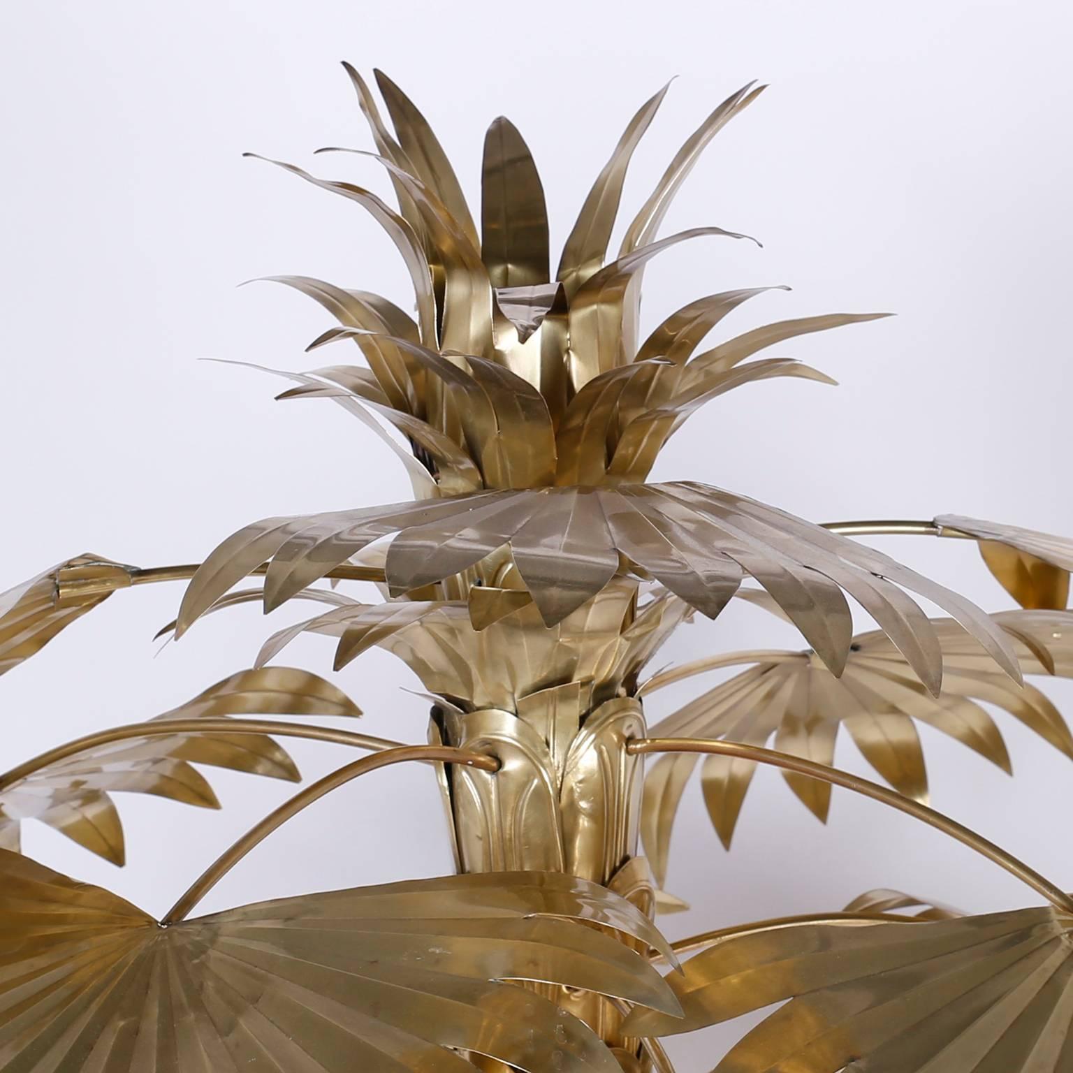 Chic midcentury brass palm tree, in the Maison Jansen manner with a refined presence and dynamic appeal. Having removable fronds and coconuts, all hand polished and lacquered for easy care. The zinc or lead base is cement filled for balance.