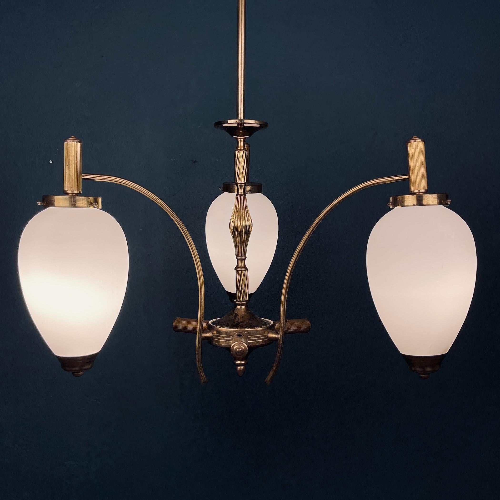 The very beautiful three arms pendant lamp of classic Italian design from the middle of the last century. Made in Italy in the 1950s. Very good vintage condition. The patina on brass. Frosted opaline glass without cracks or chips. This chandelier