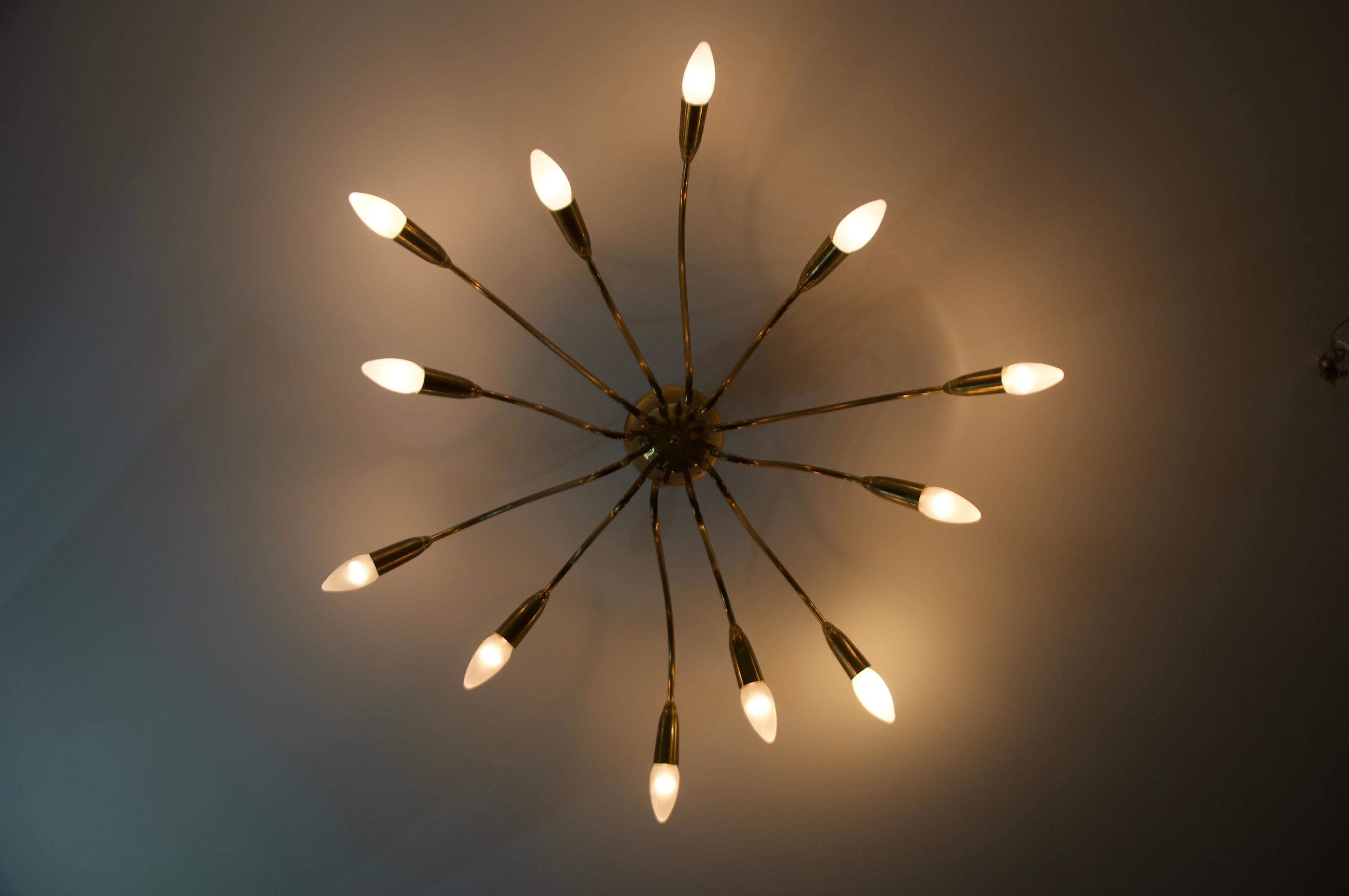Questa splendida lampada da soffitto Sputnik degli anni '50 è un perfetto esempio di design moderno di metà secolo, che combina un'audace innovazione con un'eleganza senza tempo. Realizzato in ottone di alta qualità, presenta 12 bracci di lunghezza