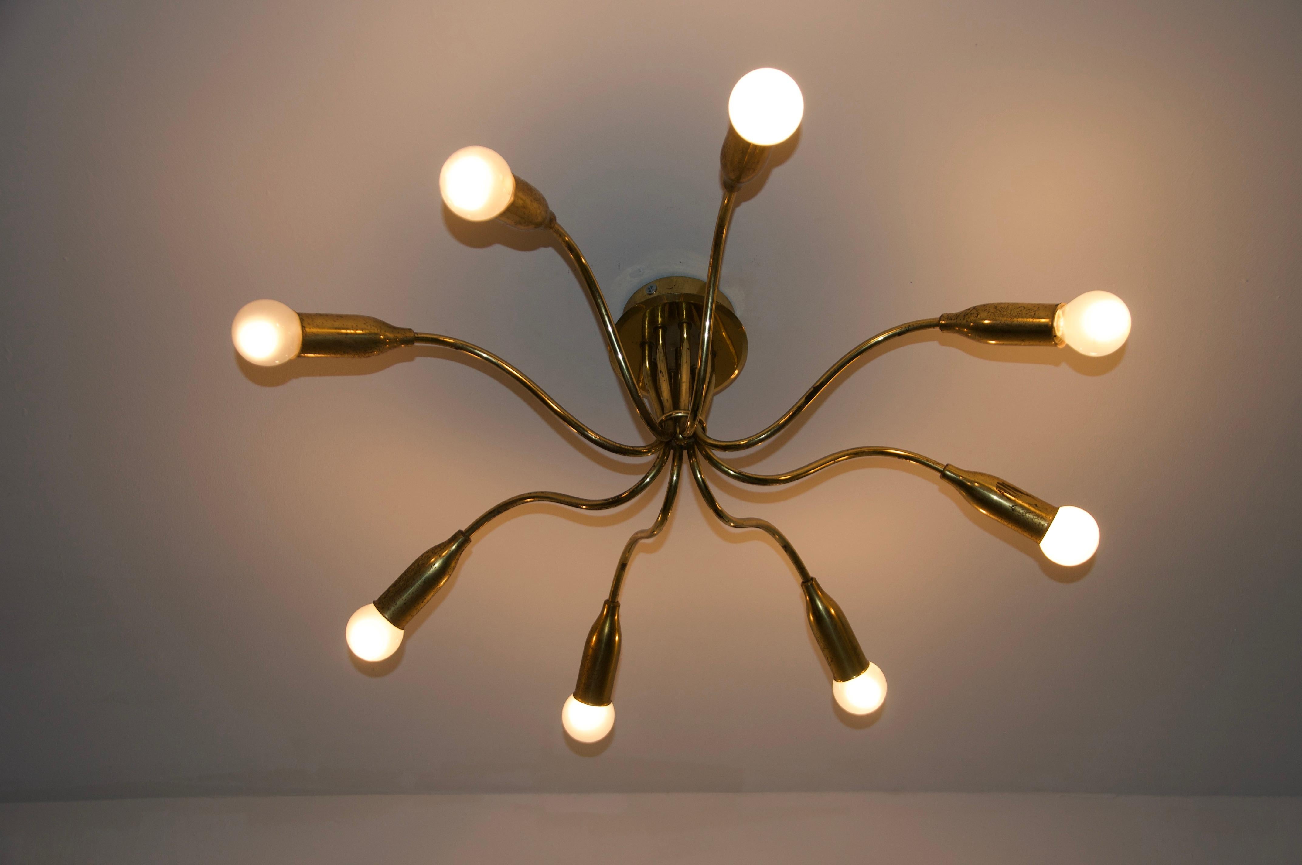 This stunning 1950s Sputnik ceiling lamp is a perfect example of mid-century modern design, combining bold innovation with timeless elegance. Crafted from high-quality brass, it features eight arms of varying lengths, creating a dynamic and