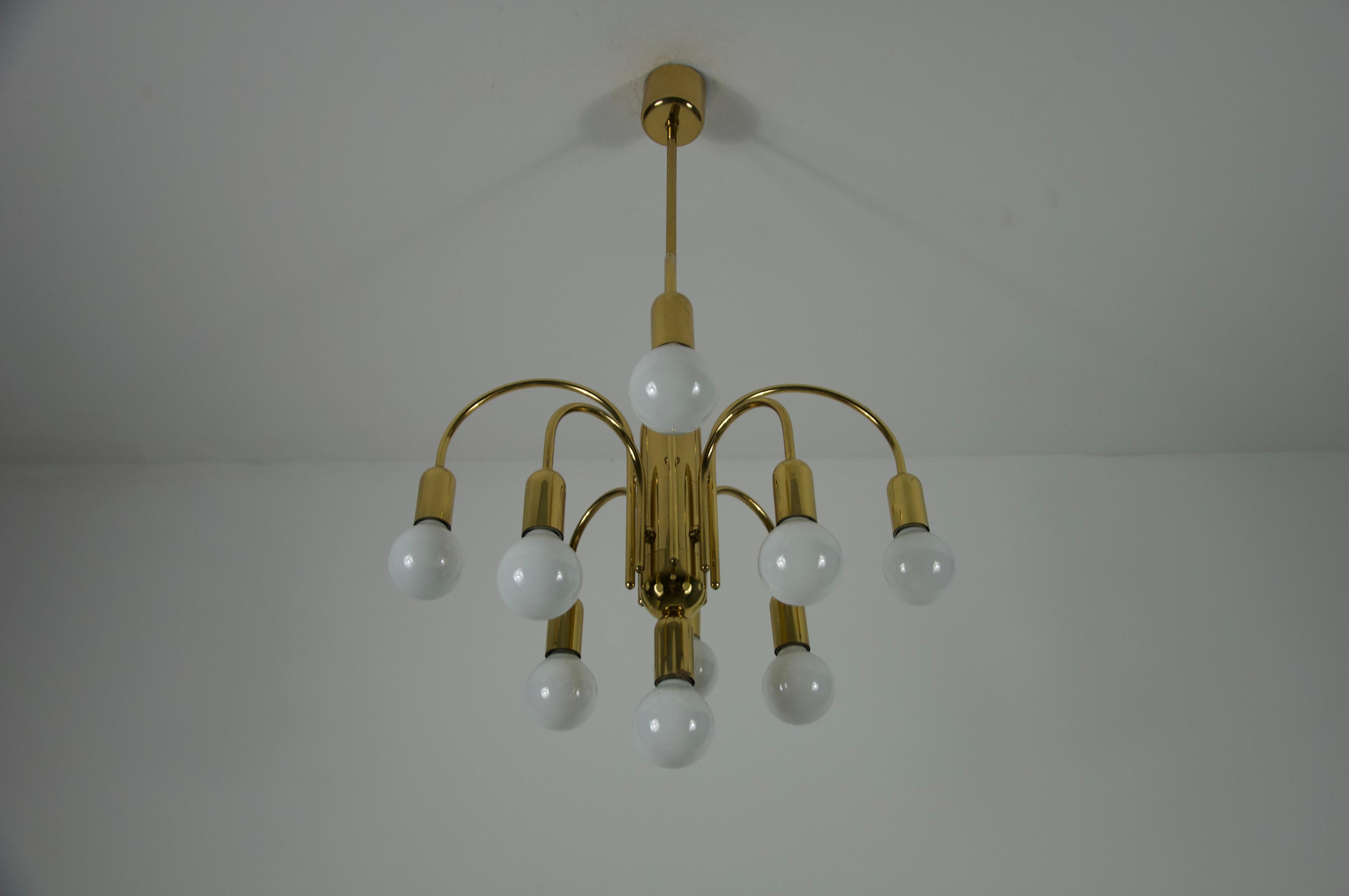 Questo straordinario lampadario Sputnik in ottone del Mid-Century, proveniente dalla Germania e risalente agli anni '50, incarna l'estetica audace e futuristica dell'era atomica. Realizzato in ottone lucido, il lampadario presenta uno stelo centrale