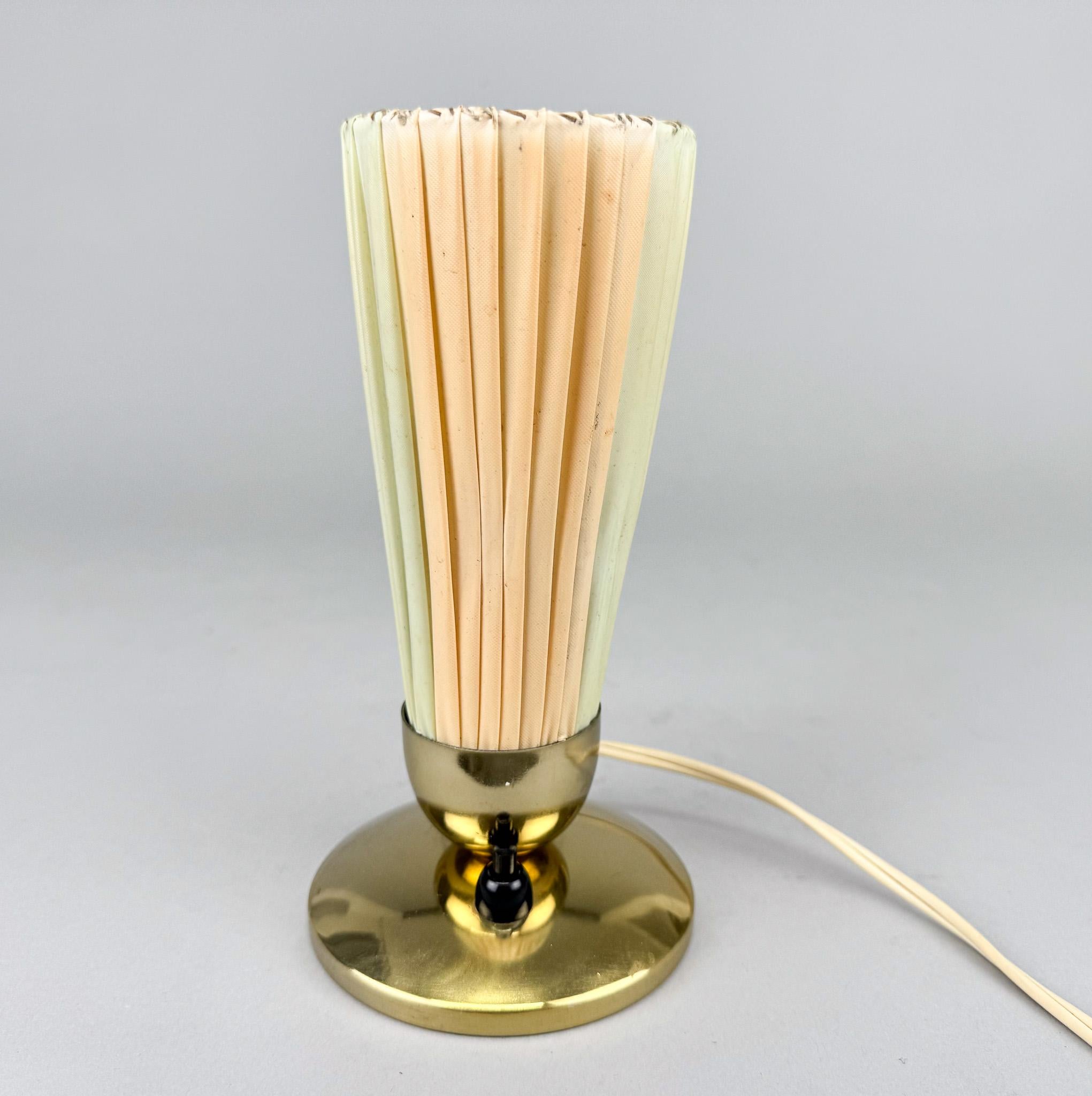 Pequeña lámpara vintage de sobremesa o mesilla con base de latón. Fabricado en Alemania en los años 60.Cableado original y totalmente funcional. Bombillas: 1 x E14. Adaptador para EE.UU. incluido.