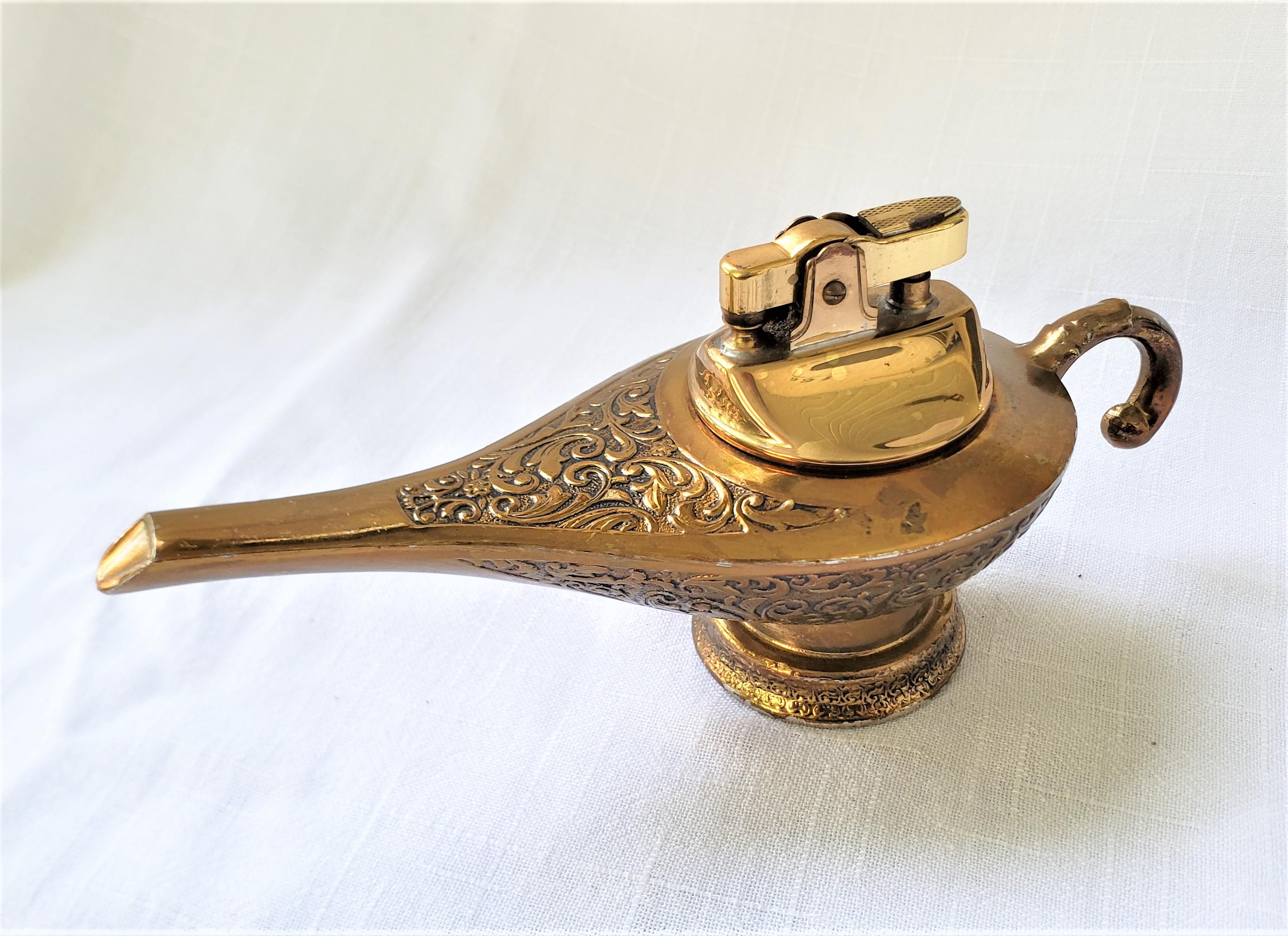 This vintage figural oil lamp table lighter is unsigned, but presumed to have originated from Japan and date to approximately 1965 and done in the period Mid-Century Modern style. The base of the lighter is composed of cast spelter with a brass