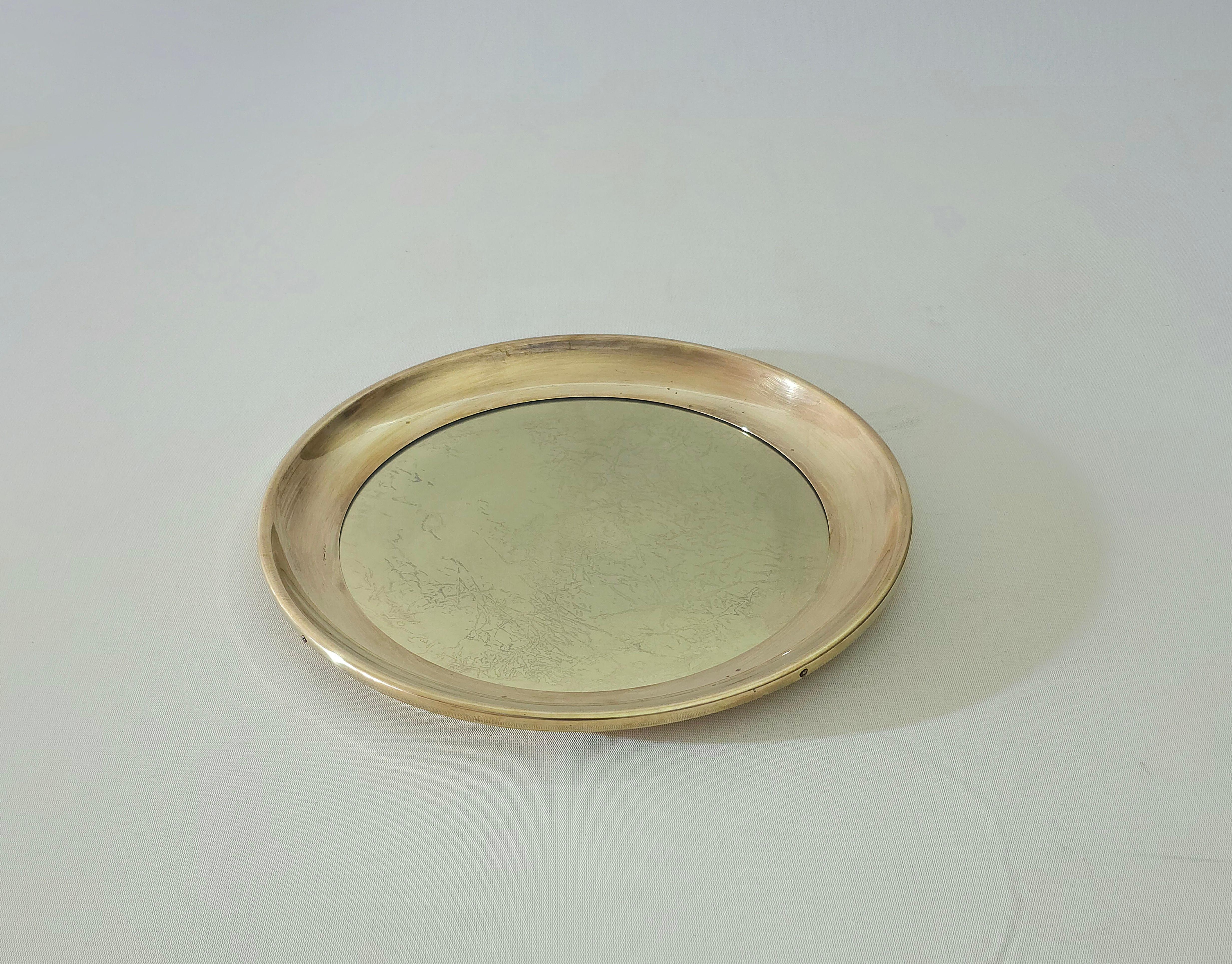 Midcentury Serving Tray  Circular Brass and Glass, Italy 1960s. Of excellent workmanship, consistent brass and pleasant curves.The base is also made of brass with a transparent glass in the center. It preserves every original piece. The object has