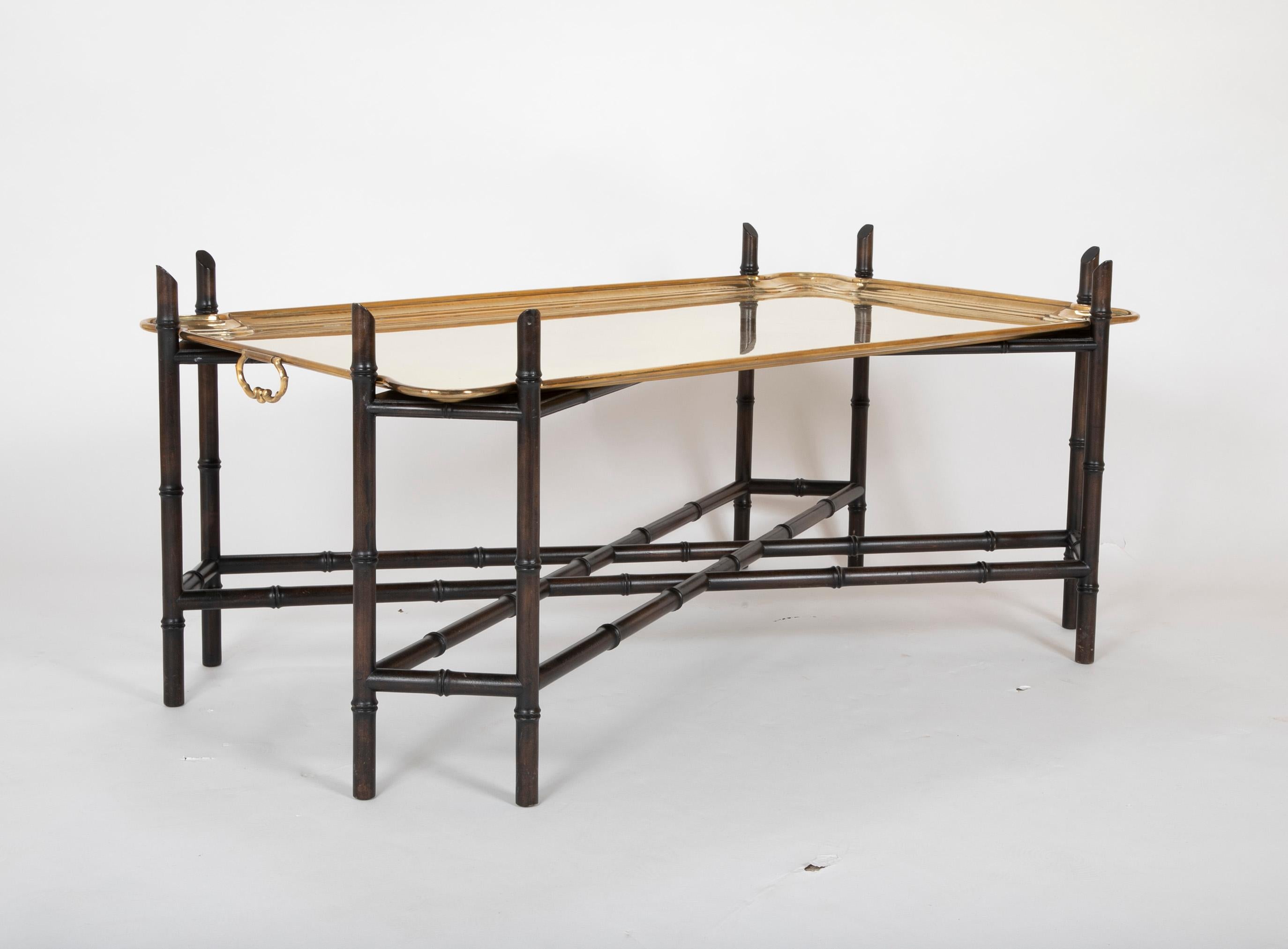 A handsome and elegant 1960s coffee table with a large scale removable brass tray top with handles, resting on an ebonized faux bamboo base. This is a great piece for a traditional interior and will mix well with modern, contemporary and midcentury.