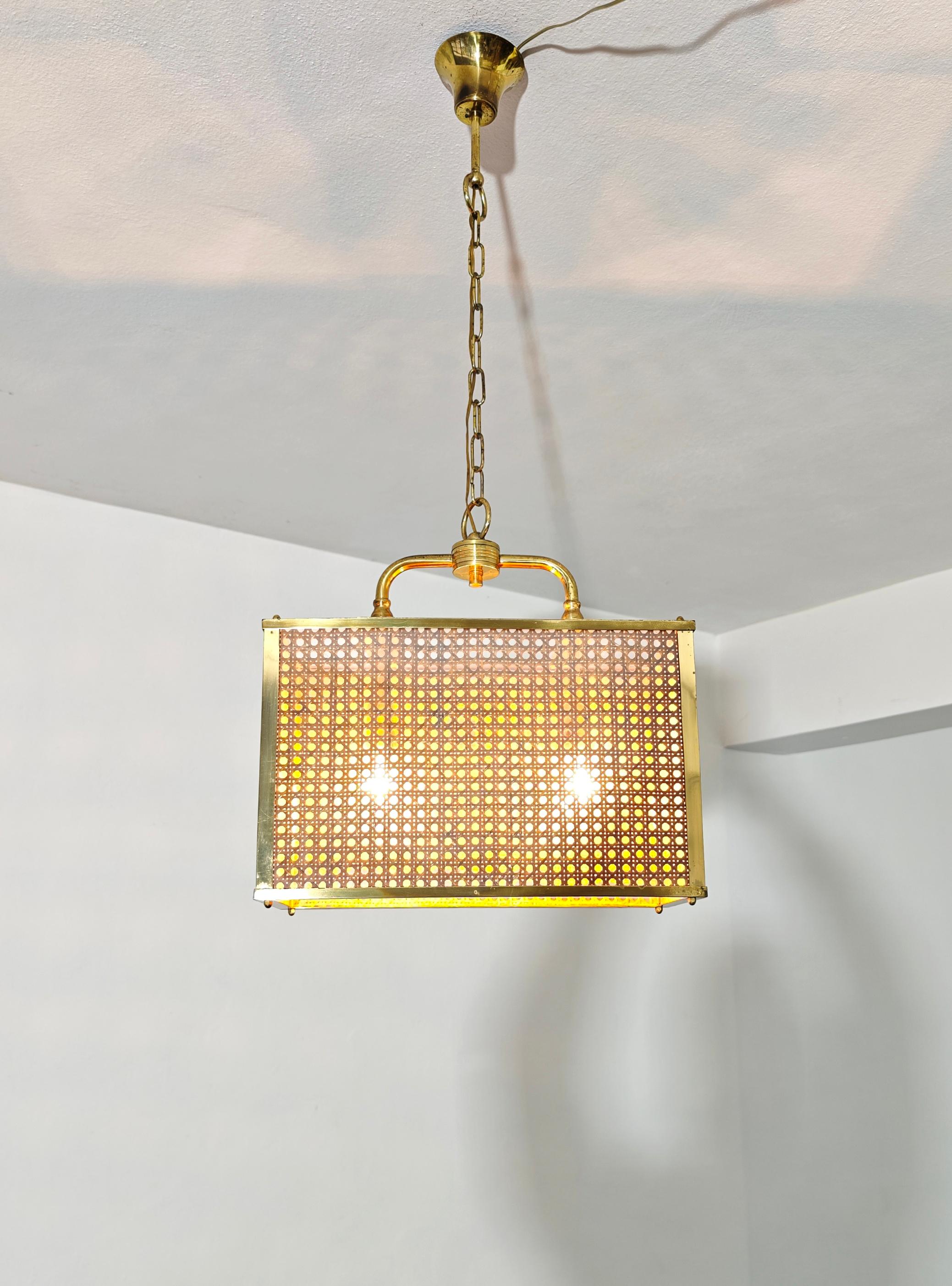 Lampe suspendue à deux lumières avec cadre en laiton, diffuseur parallélépipédique en plexiglas transparent et osier tressé. Rare en son genre, à ne pas sous-estimer. Veuillez regarder attentivement la vidéo et les photos, merci. 

2 lumière : E