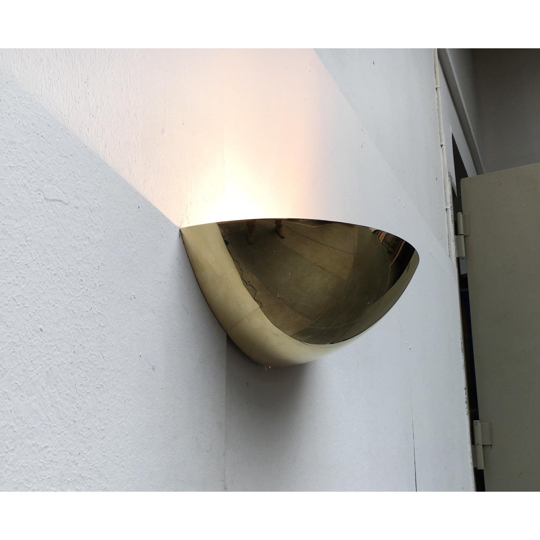 Simple Mid Century wall lamp made of brass.

A classic and elegant design. A simple shell made of brass. The light exits upwards. The polished surface reflects the surroundings. An imposing wall sconce when switched on as well as off.
The lamp is in