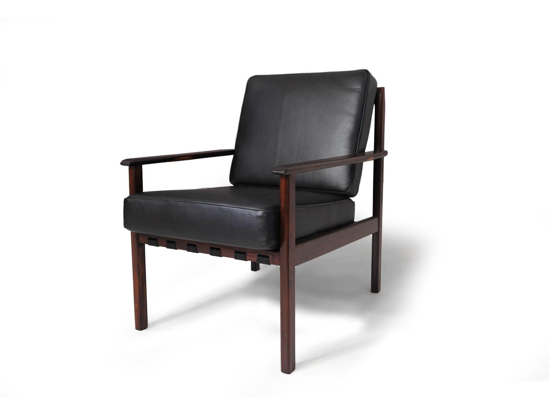 Mid-century Brazilian lounge chairs crafted from dark jacaranda, newly upholstered in black leather. The chair frames have been lightly restored with a natural oil finish and updated with new strapping, foam, and leather for added comfort and