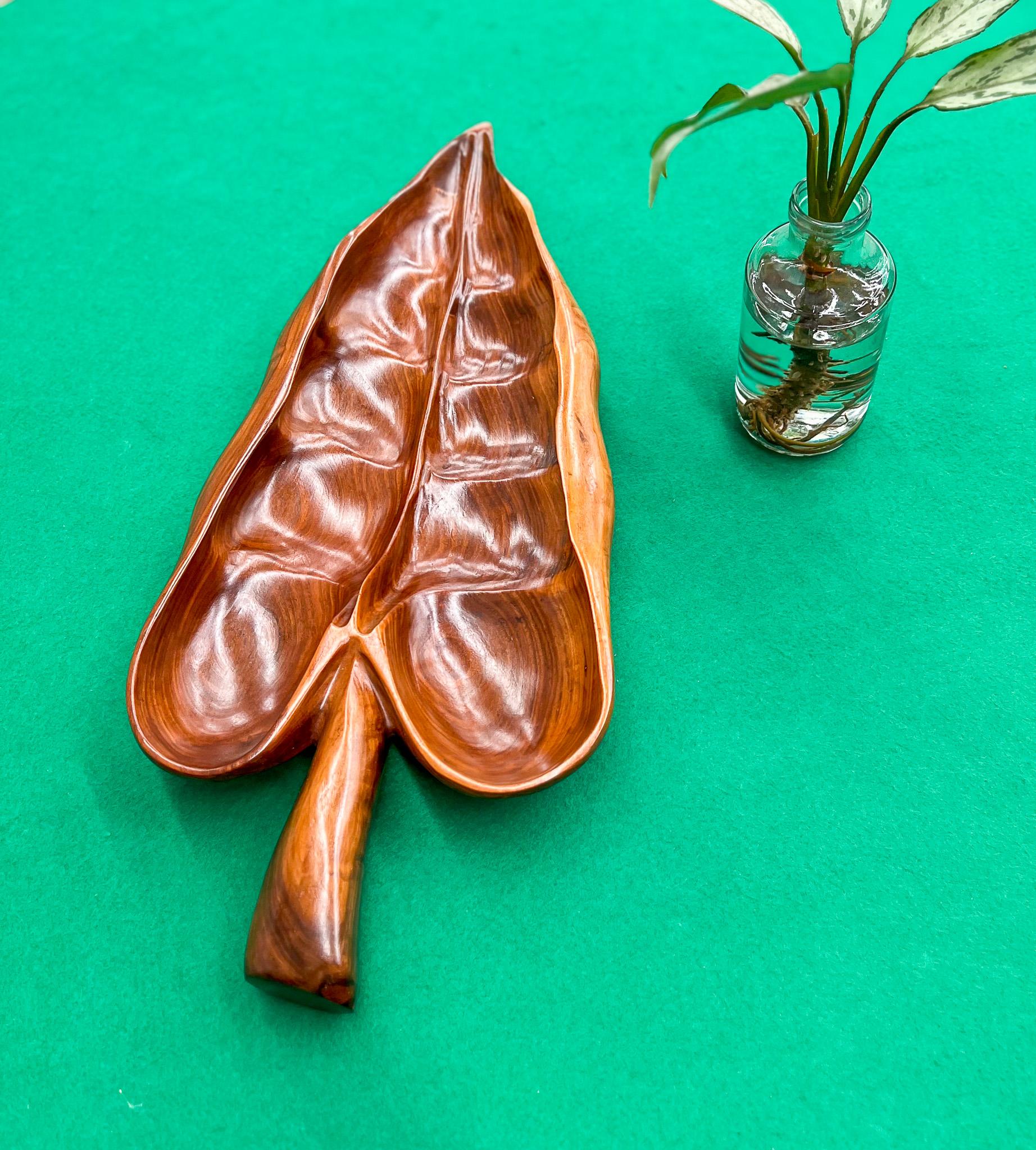 Available today, this Midcentury Brazilian Modern Decorative Platter with Leaf-Shape was made in Brazil during the sixties. Handcrafted from noble wood, the serving platter features smooth curves and delicate woodwork emulating a tropical leaf from
