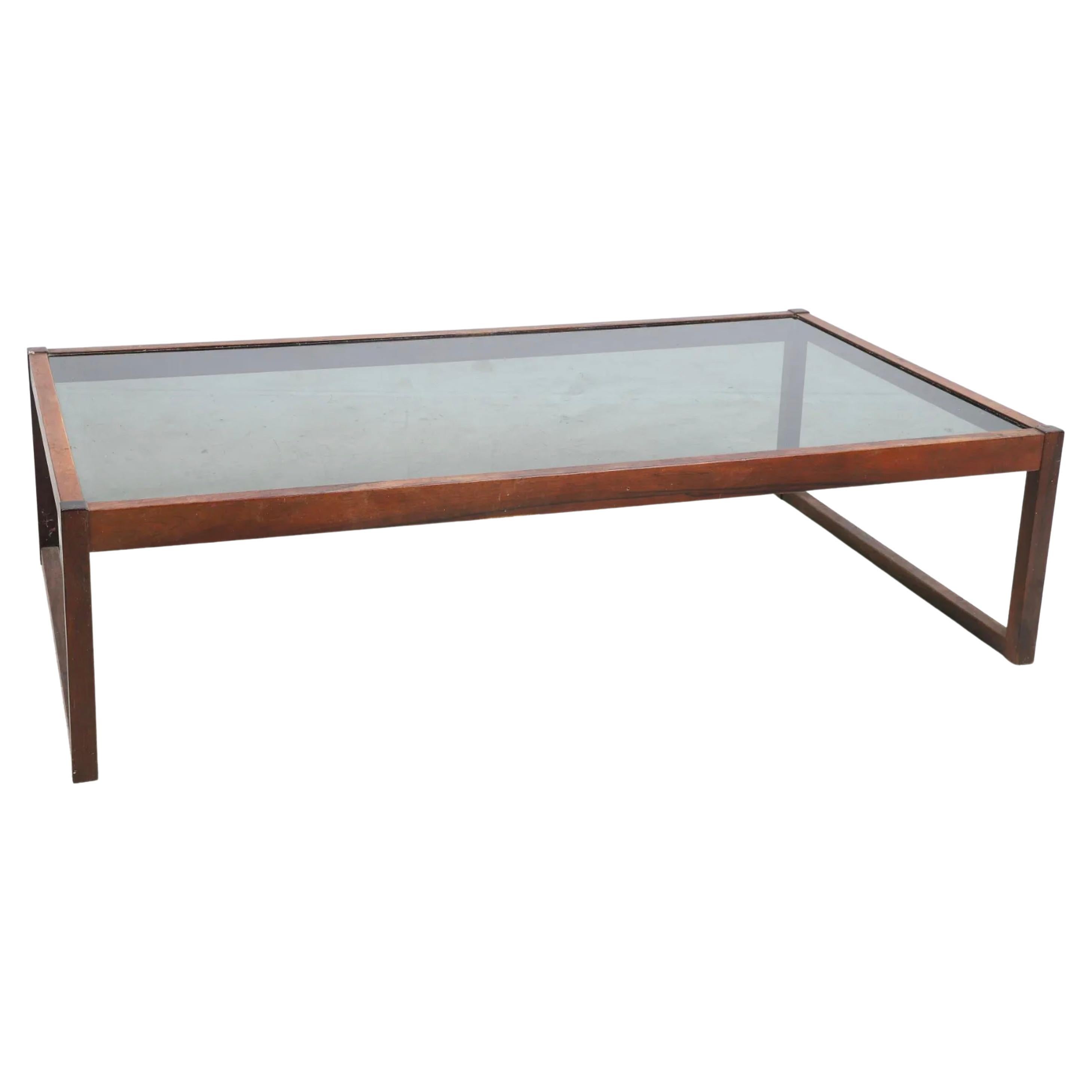Mid Century Modern Design rosewood glass top coffee table with smoked glass insert. Solid rosewood frame. Good vintage condition shows signs of use on glass top. Made in Brazil. Located in Brooklyn NYC

57