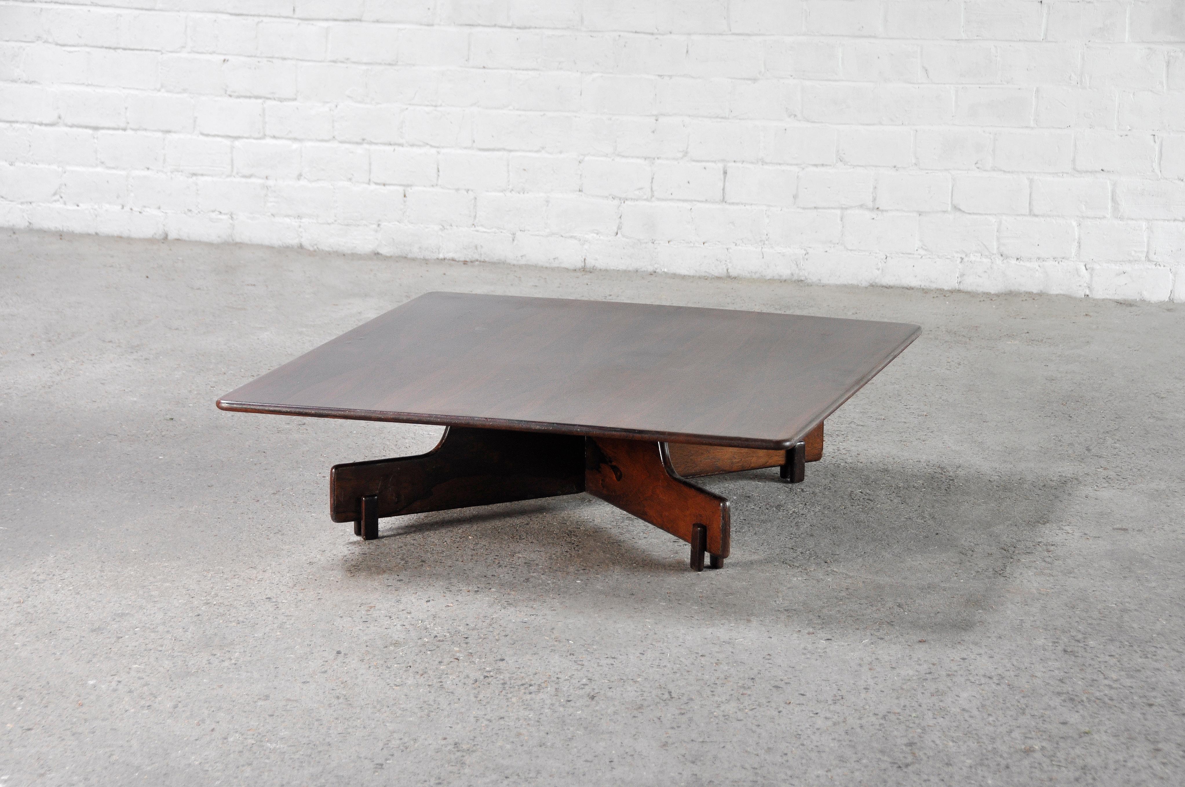A beautiful low Brazilian coffee table in Brazilian jacaranda/rosewood veneer. This table dates to the 1960's and is attributed to Sergio Rodrigues due to its typical matching design features. The warm hue of the wood combined with its low and sleek