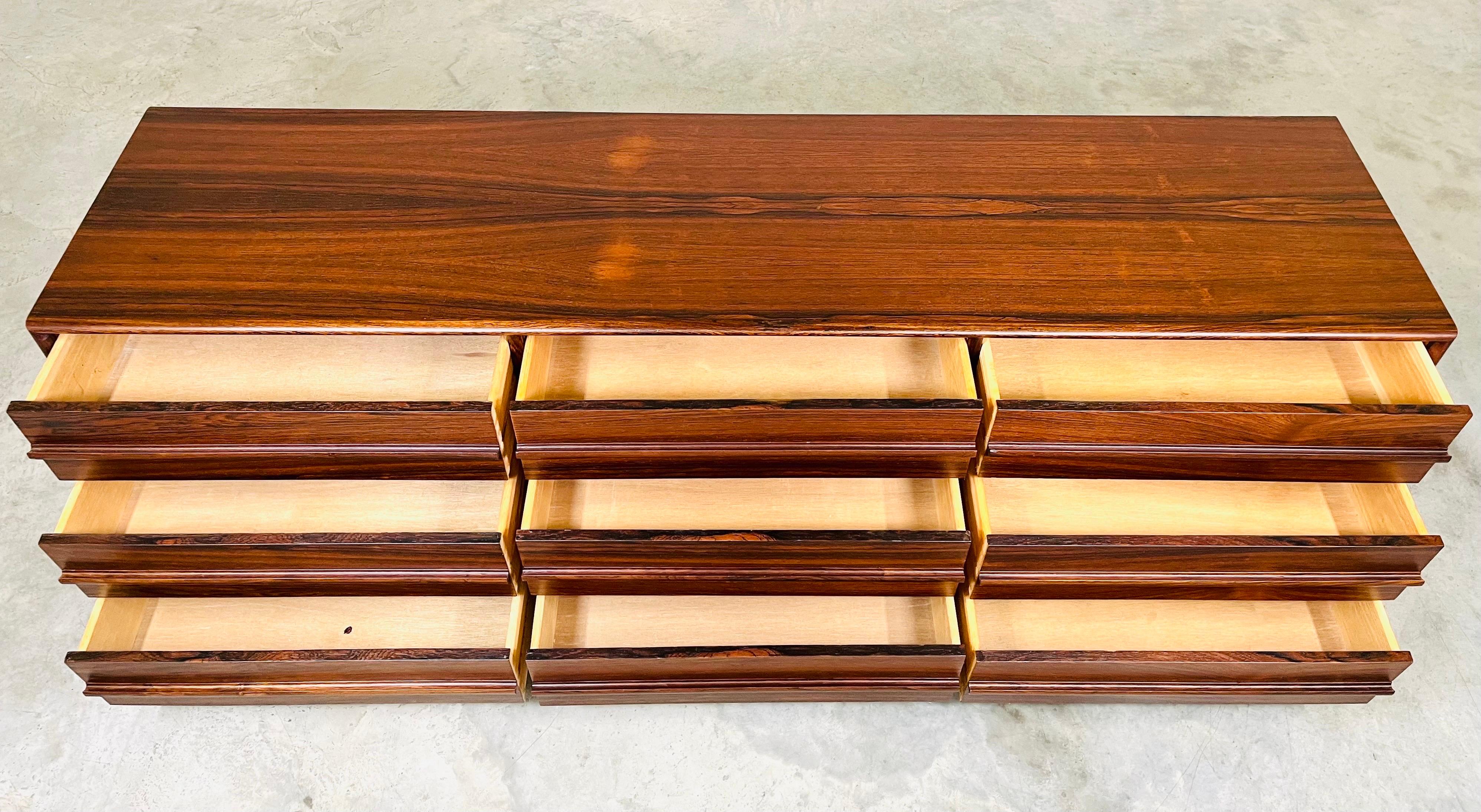 Une superbe commode triple à 9 tiroirs en bois de rose brésilien à la manière d'Arne Vodder par Inter-Continental-Design Limited du Canada vers 1970. 
Le grain est magnifique. Toutes les façades de tiroirs sont assorties, avec des poignées
