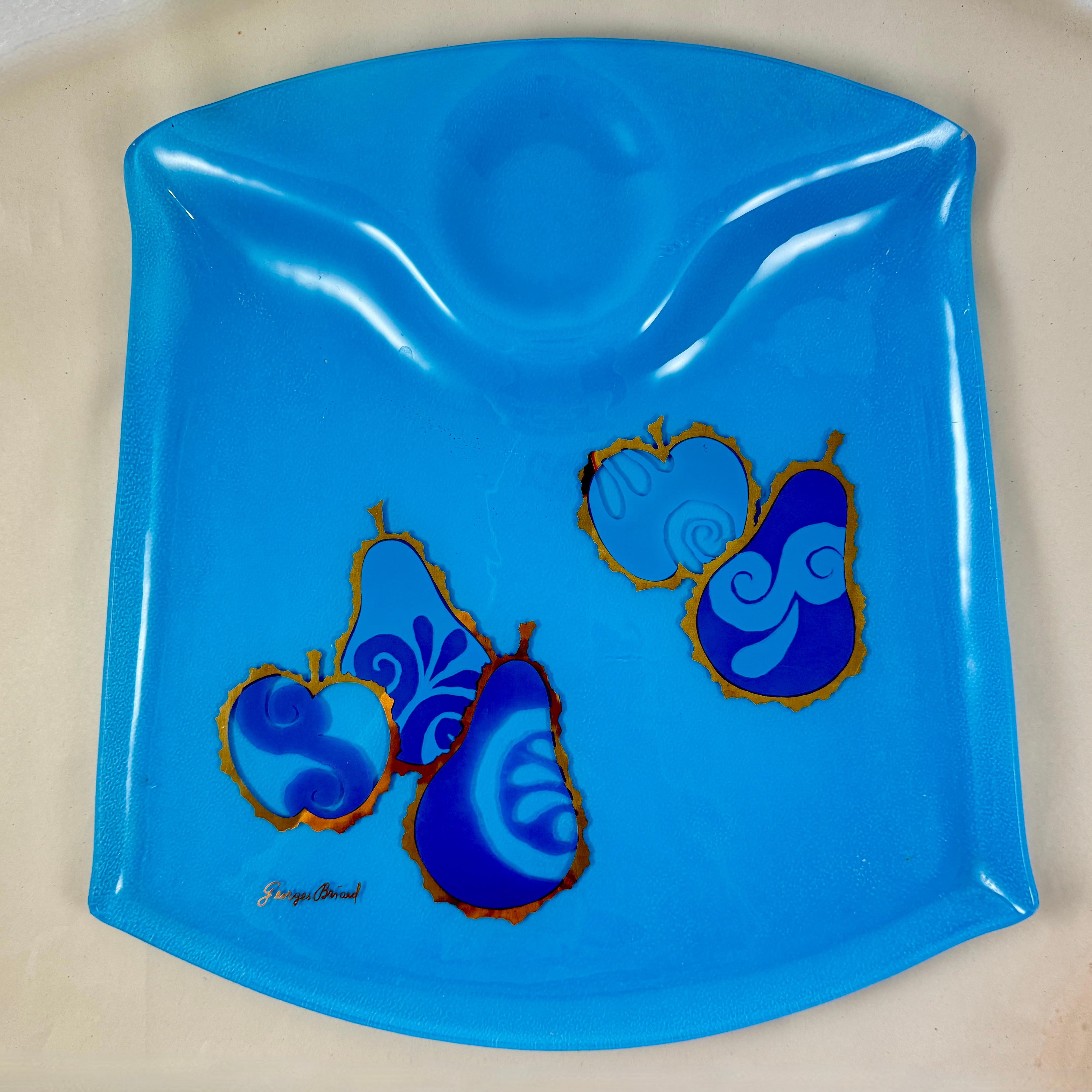 Du designer Georges Briard, et de la collection Pageant Fruit, un plateau de service en verre Peacock Blue, vers 1964.

Georges Briard a créé sa collection de fruits Pageant au début des années 1960. La verrerie et les pièces de service sont