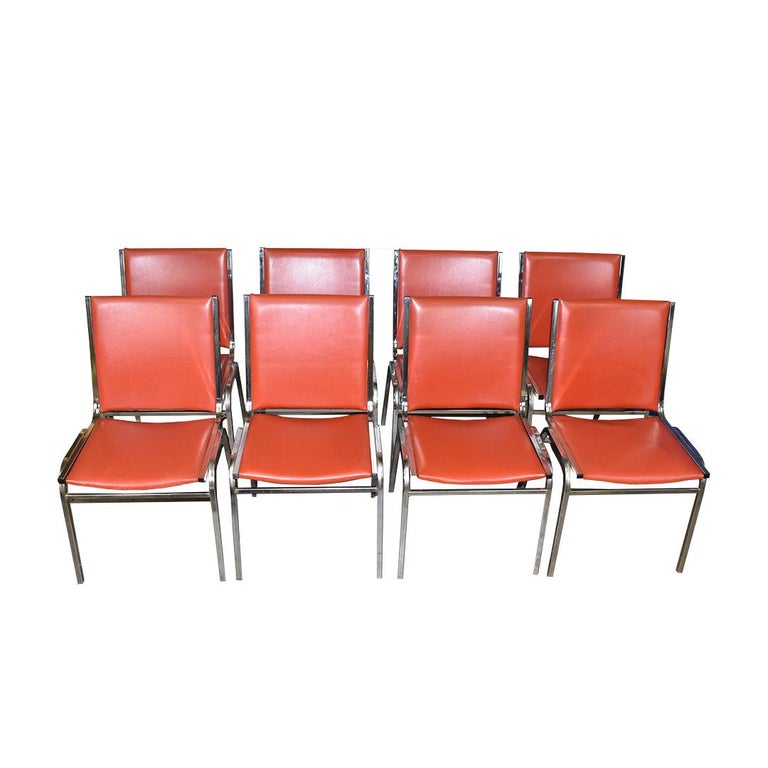 Set of 8 chrome and red vinyl dining chairs. Fantastic midcentury design with chrome legs and back stretchers. Red vinyl seats and chairbacks will give any dining room a fantastic pop of color. 

Measures: 19.25” wide
Seat height 17”
Seat depth