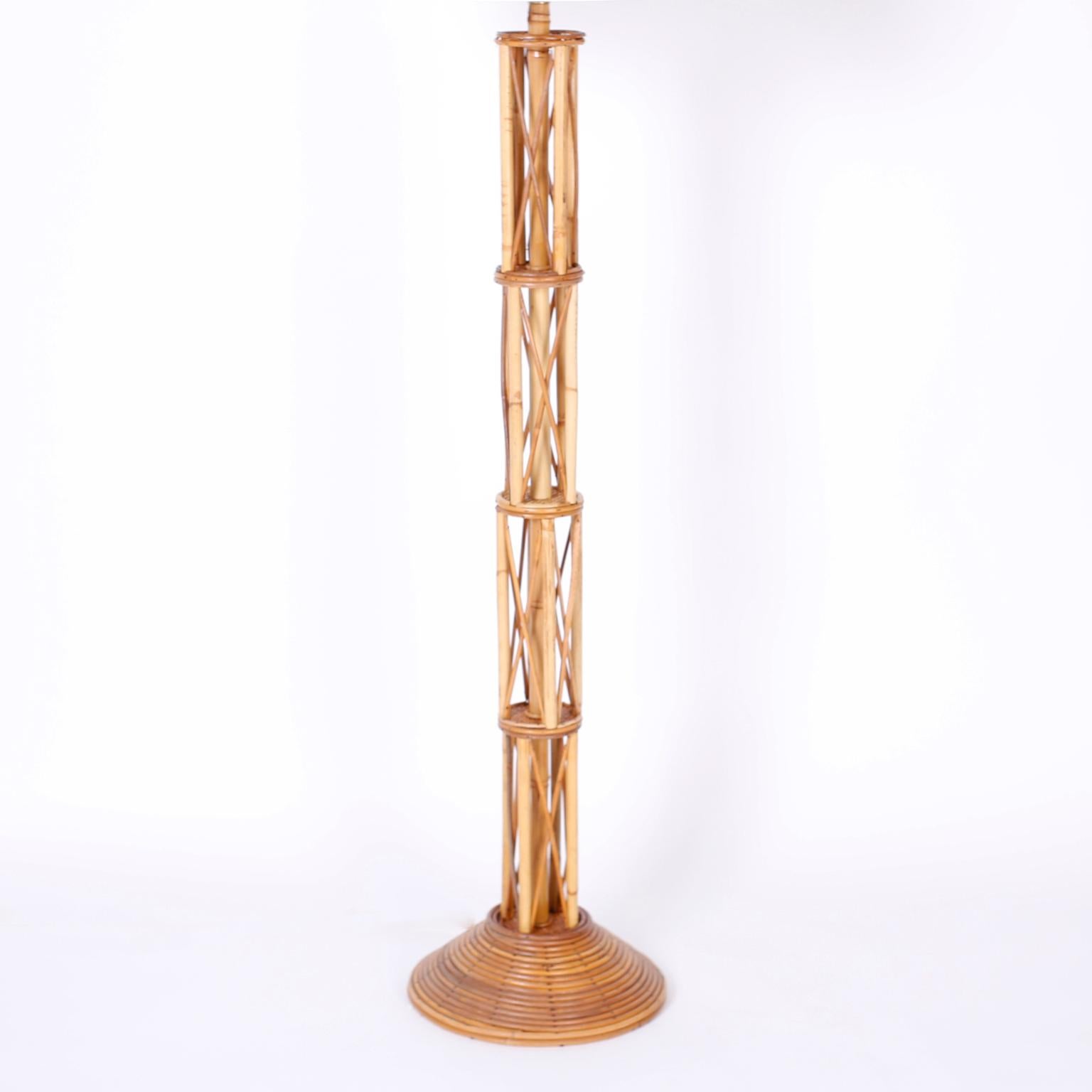 Mid century floor lamp crafted in bamboo and rattan, with four levels bamboo and crossed rattan, divided by grasscloth discs on a round rattan base.
