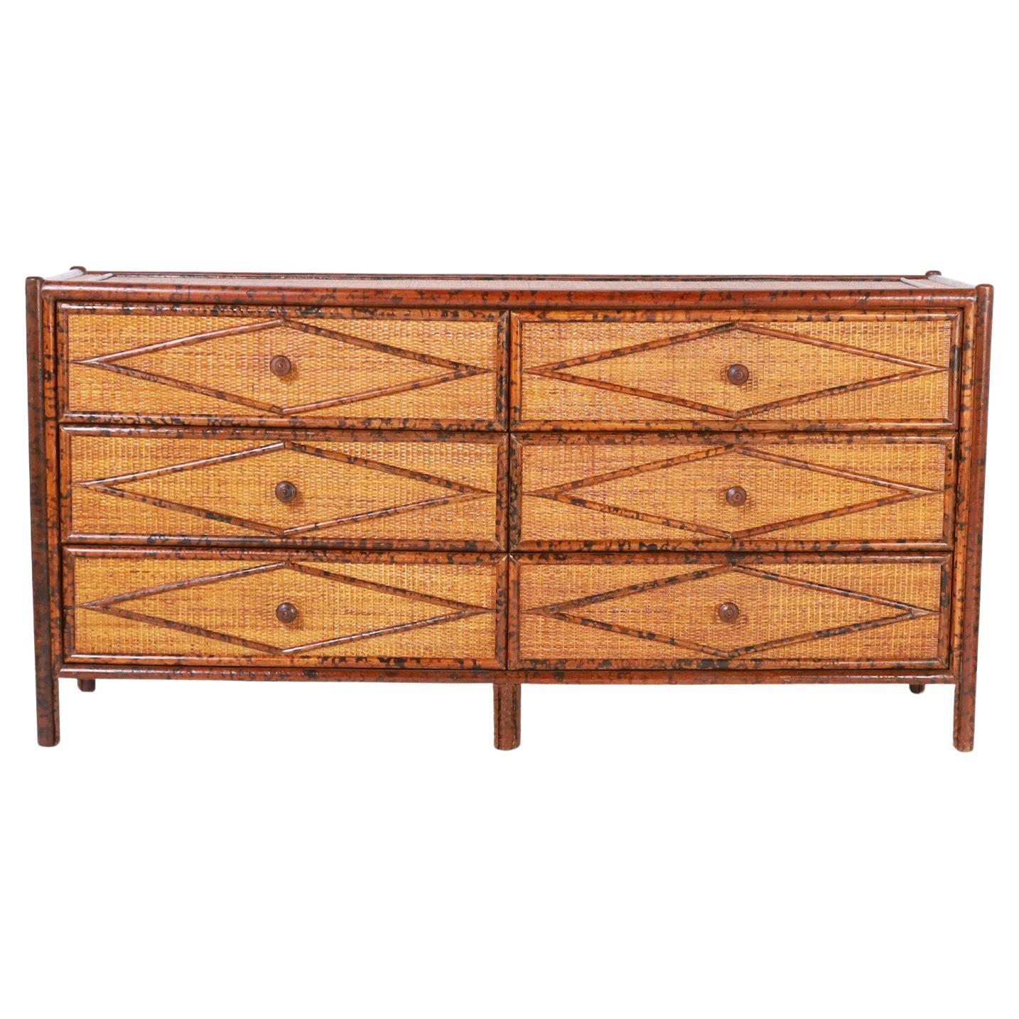 Vintage British Colonial chest of six drawers crafted with a faux bamboo frame having a faux tortoise finish and grasscloth panels all around with applied geometric designs.