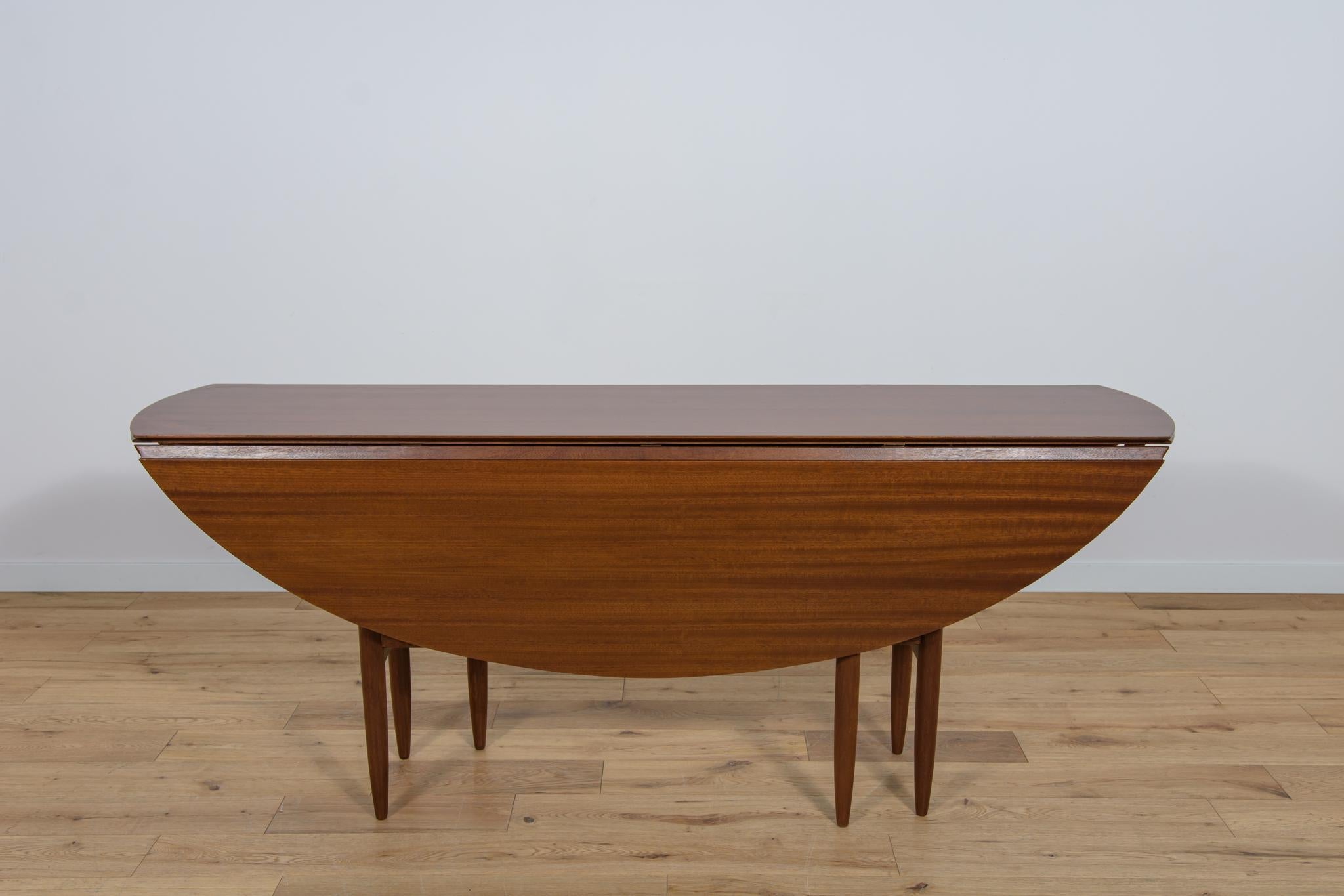 Extendable table, manufactured in Great Britain in the 1960s. The entire piece has undergone a comprehensive carpentry renovation. The set is made of mahogany wood. The wooden elements were cleaned of the old coating, veneer defects filled, painted
