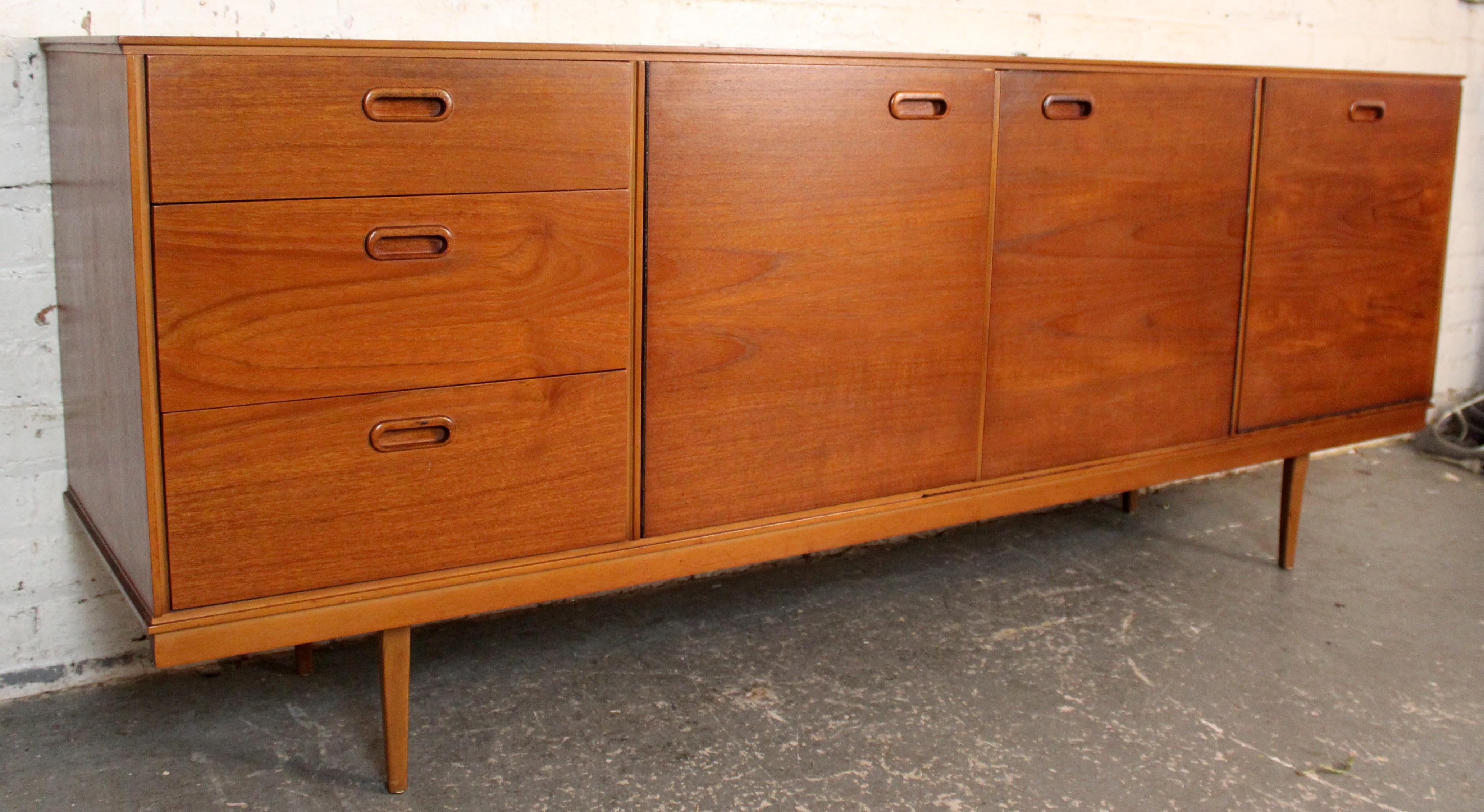 Una credenza in teak di metà secolo, elegante e senza tempo, realizzata dal rinomato produttore britannico Avalon Yatton. Caratterizzato da linee pulite, cassetti scolpiti e un ampio spazio di archiviazione, questo mobile incarna il classico design