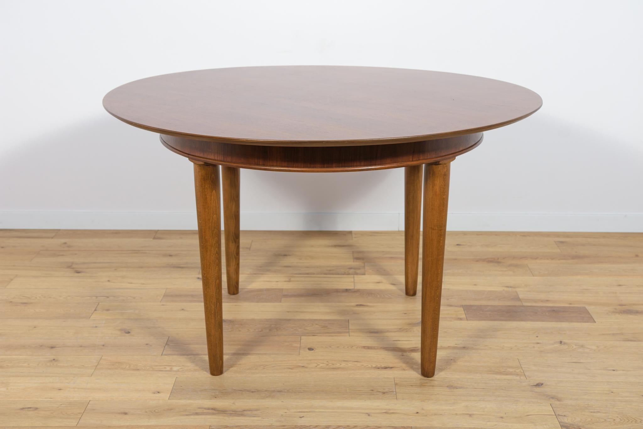 A round table made of teak wood, manufactured in Great Britain in the 1950s. The table has an interesting grain. The furniture has undergone comprehensive carpentry renovation. It was cleaned of the old surface, painted with oak stain, and finished