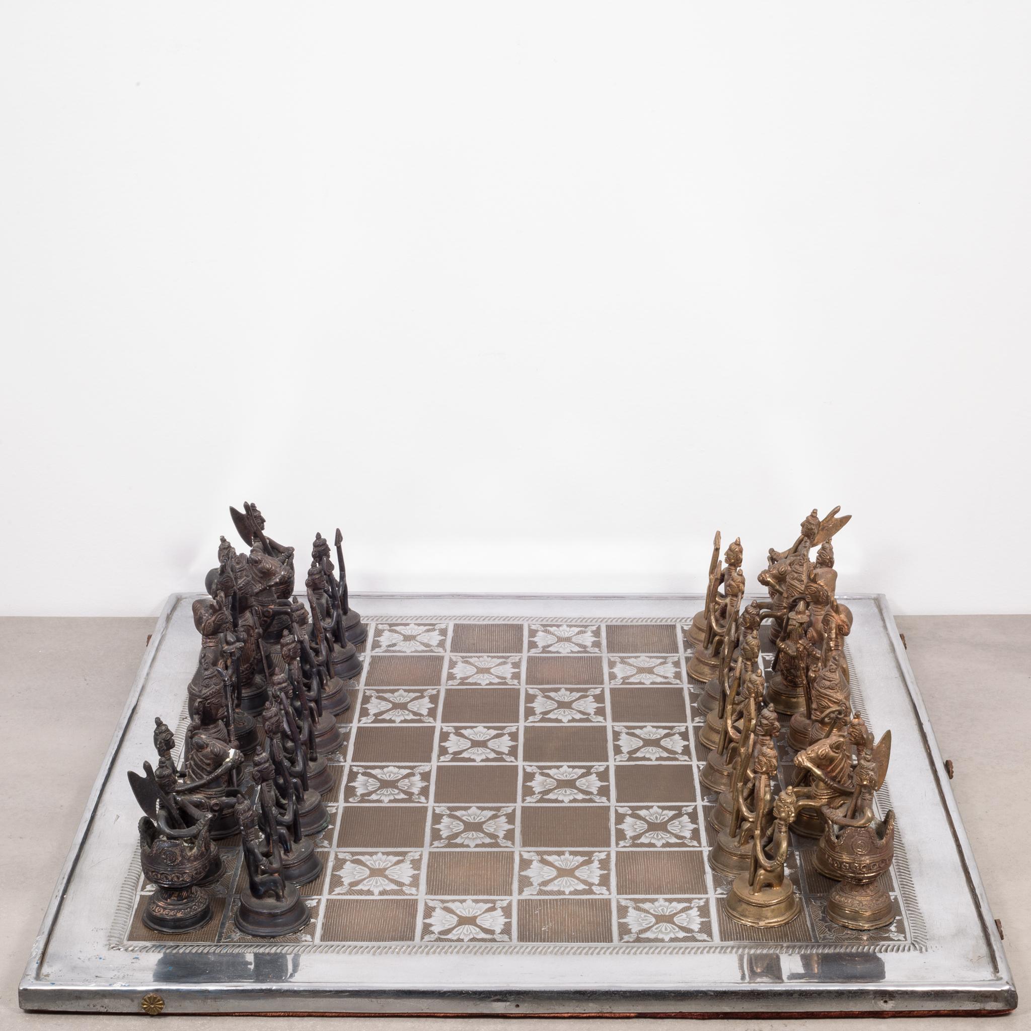About

This is an original chess set made in India with solid bronze and solid brass chess pieces. The chess board is aluminum and inlaid brass with rosettes on the sides and felt on the bottom. This piece has retained its original finish and has