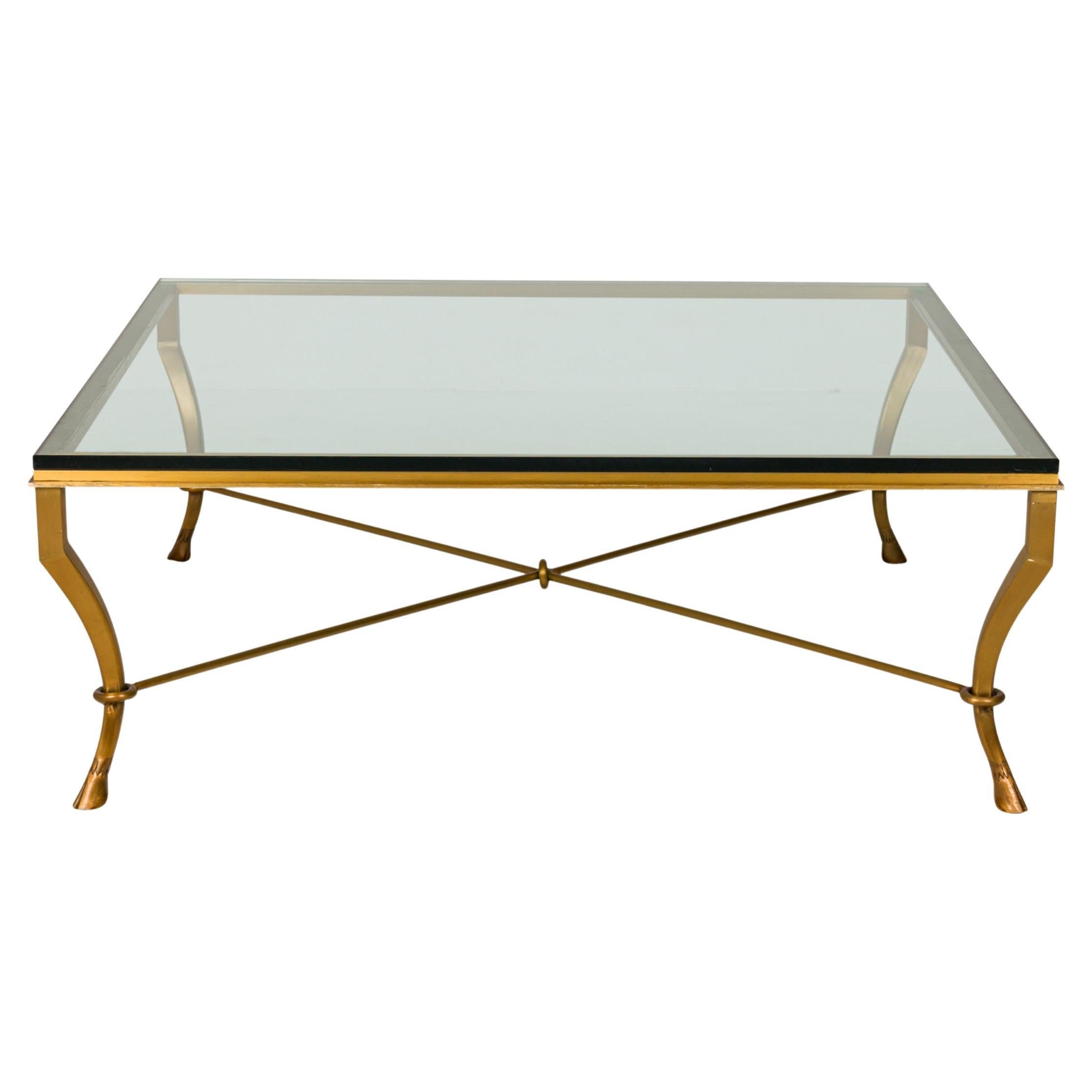 Table basse/table à cocktail mi-siècle en bronze et verre transparent avec pied en forme de sabot