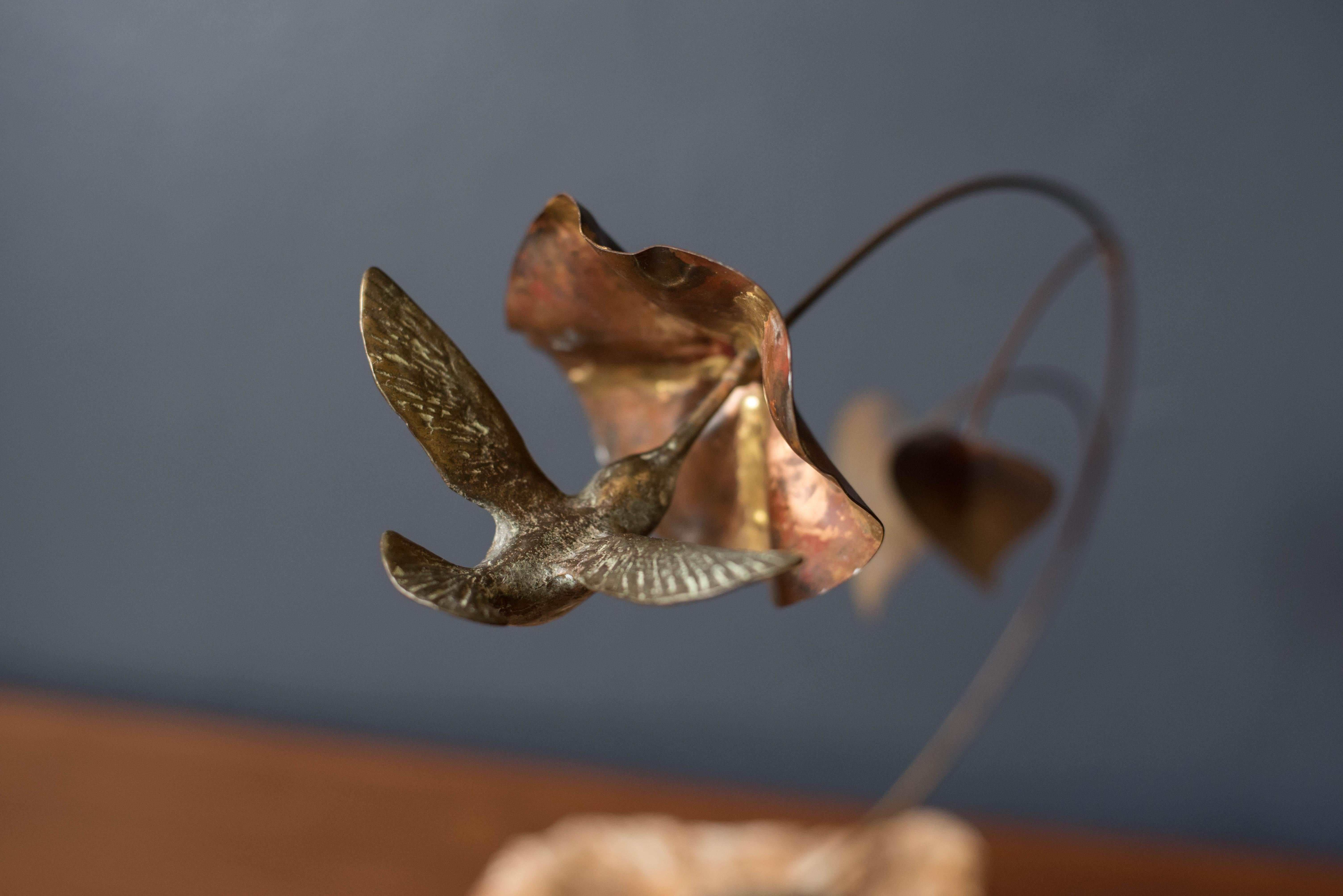 Vintage bronze sculpture on stone signed Bijan circa 1970's. This playful design of 'Hummingbird with Flower' is suspended with mixed metals that is mounted on a heavy striated stone base.