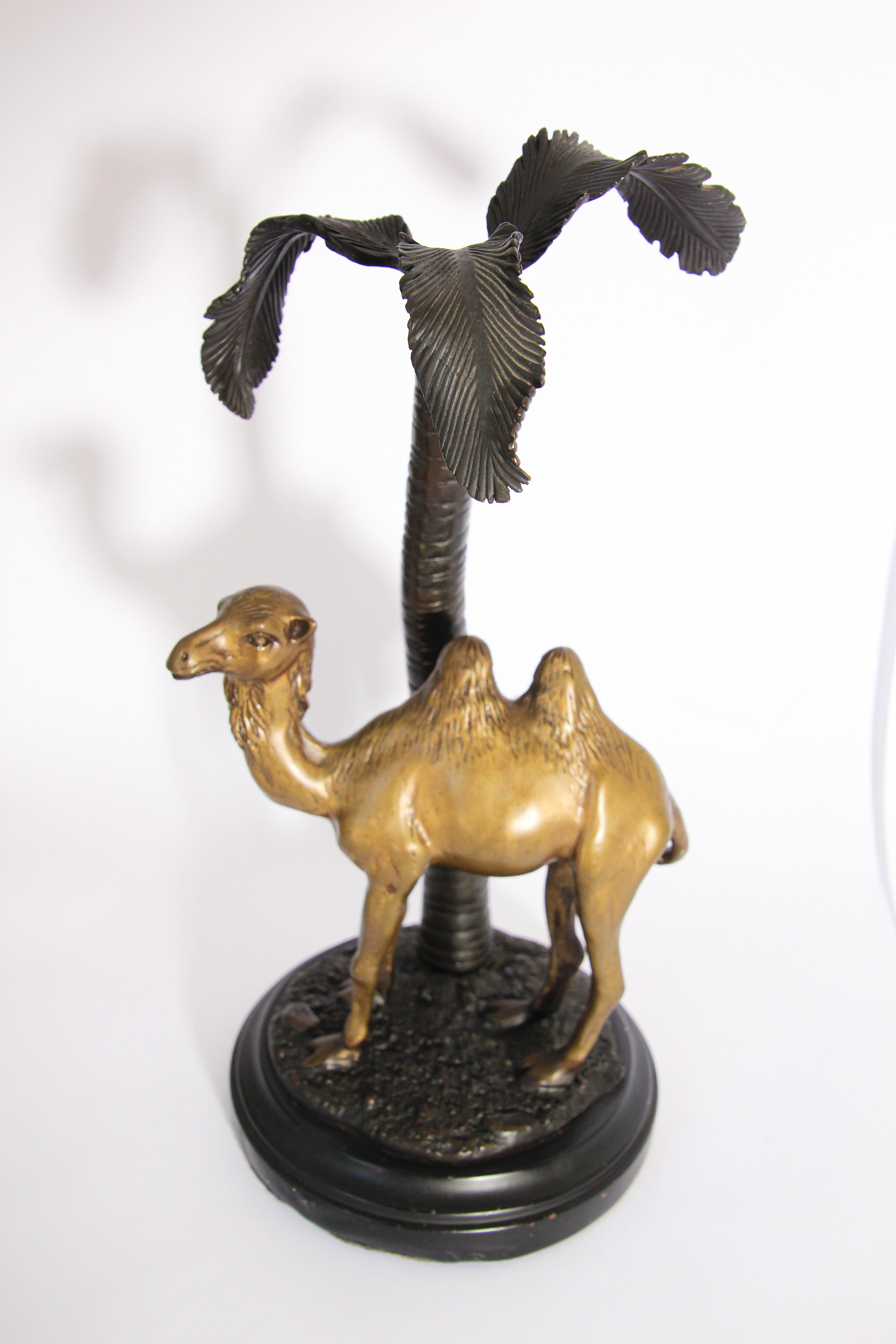 Beautiful Arabian orientalist style artwork of a brass metal camel standing under a bronze palm tree.
The patina finish is stunning in its deep, rich tones for the tree and base, the camel is in cast brass.
The group was designed to be a table