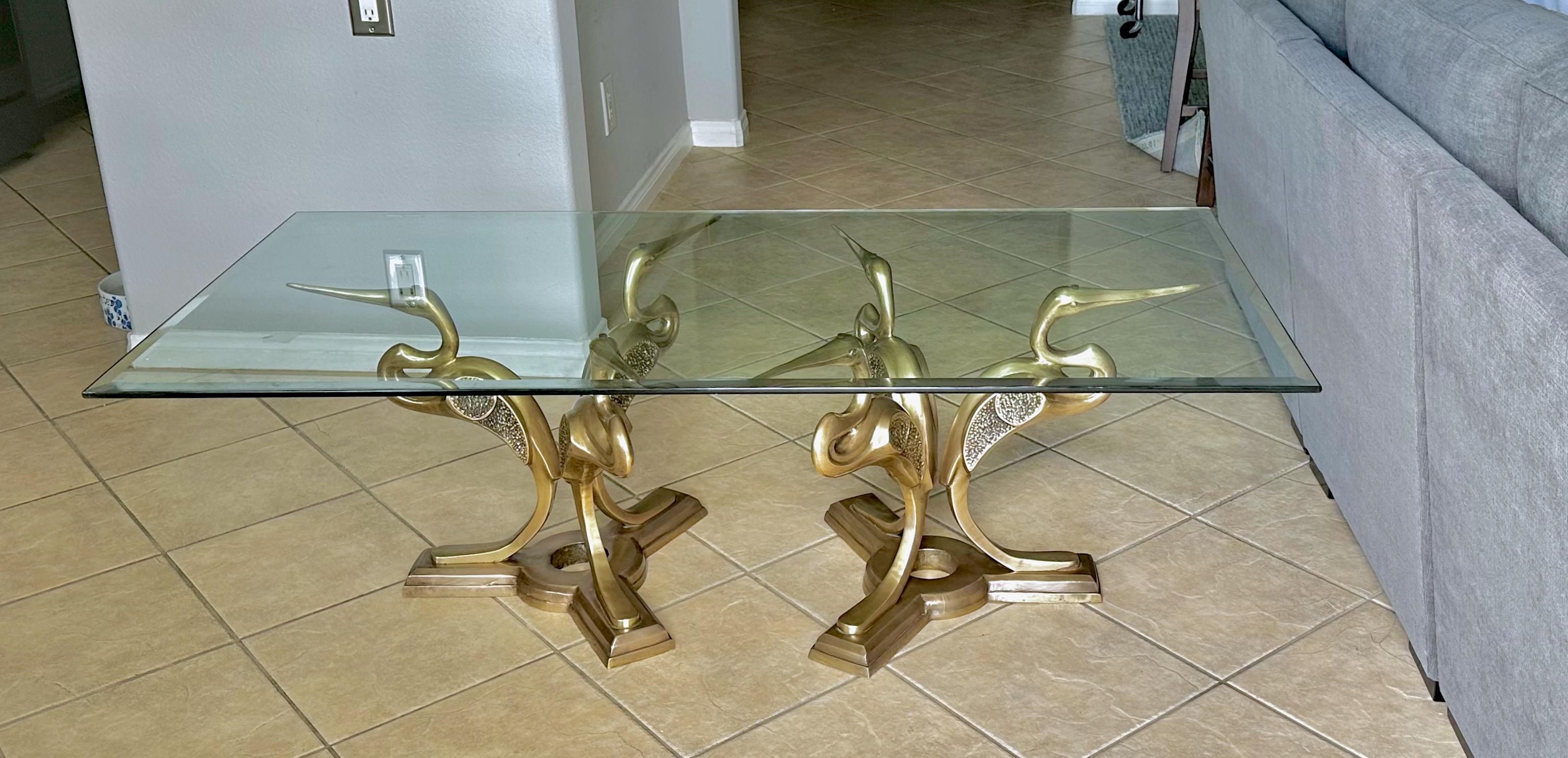 Crane or Heron bird form cast bronze or brass coffee table in style of Willy Daro. Includes thick beveled edge glass top. The two table bases are identical, each with 3 cranes forming a tripod. Rare to see this style table especially a pair. Has the