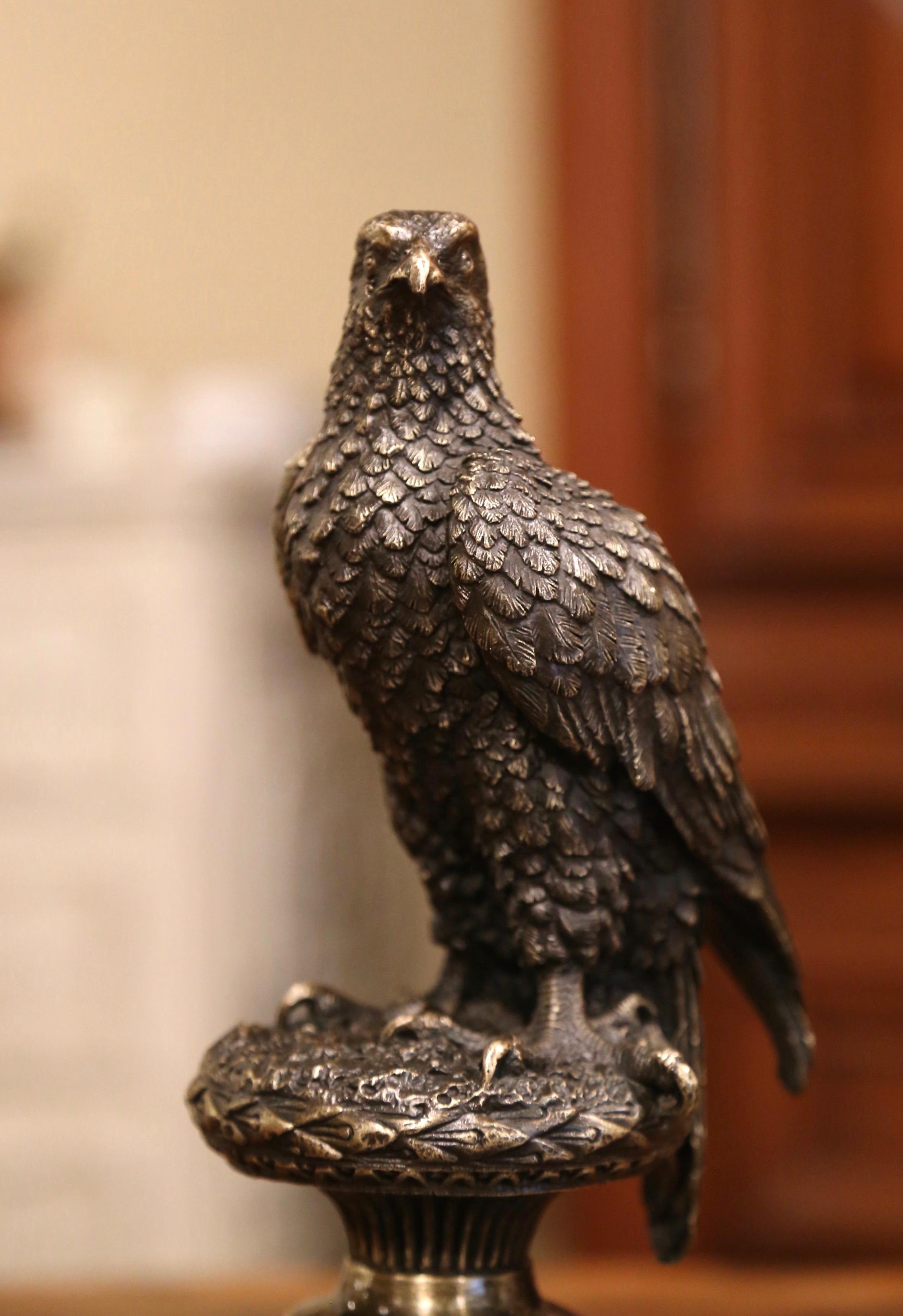 Created in France circa 1950, the sculpture depicts a young feathered eagle with large talons perched on a round gilt base. The piece which has reeding and fluting also mounted on an integral neoclassical style real black marble lower base. The