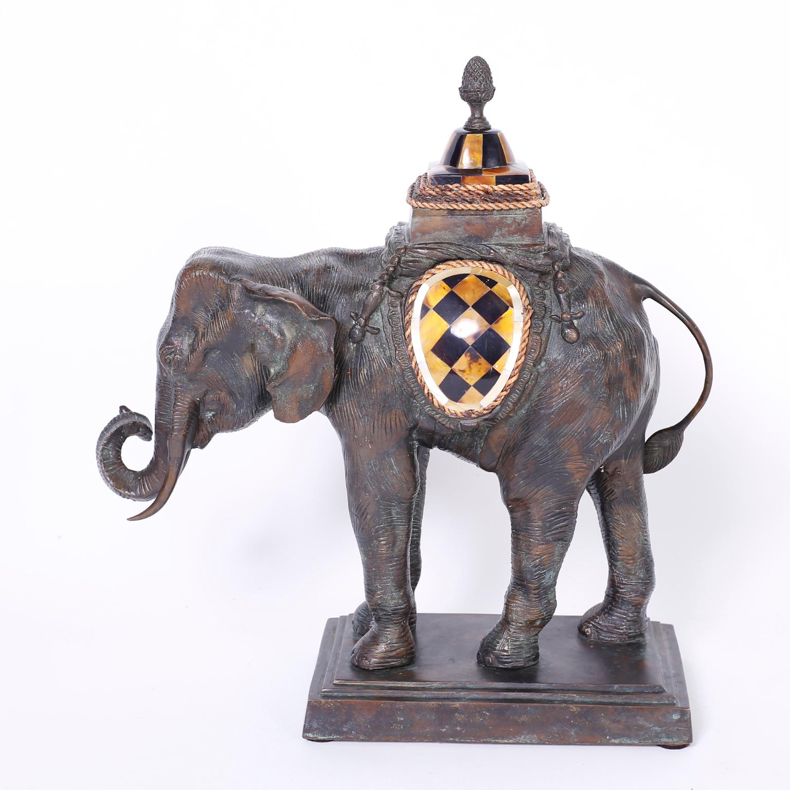 Decorative elephant sculpture or object of art crafted in bronze with a three tone patina, and decorated with panels of horn bordered with rope and topped with a pineapple finial. Signed Maitland-Smith on the bottom.