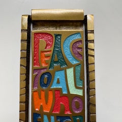 Battente di metà secolo in bronzo e smalto "Pace a tutti coloro che entrano qui".