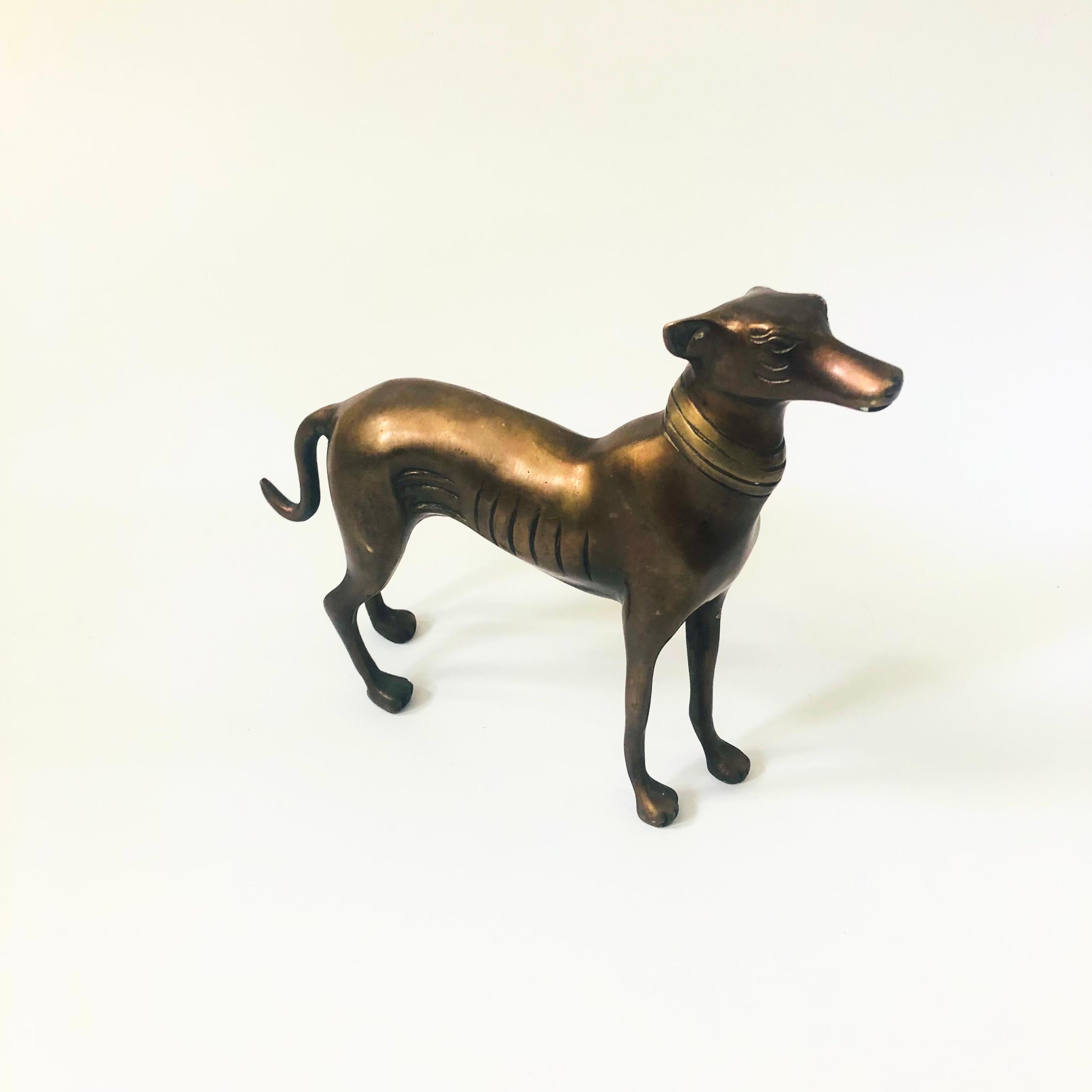 Una statua di levriero in bronzo della metà del secolo scorso. Grande design stilizzato di metà secolo, colorazione scura del bronzo.

