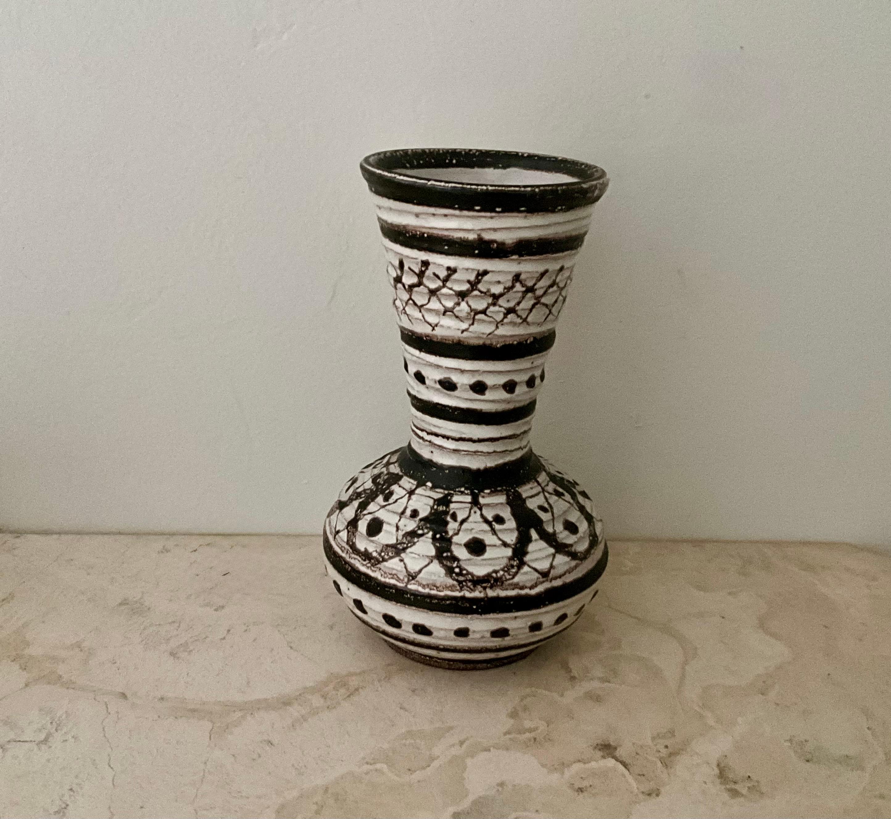 Mid-Century Brown and White Studio Pottery Vase, 9.5” High

Description:
Mid-century studio pottery vase with a striking brown and white glaze, featuring incised and textured geometric patterns. The form flares gracefully from a rounded base to a