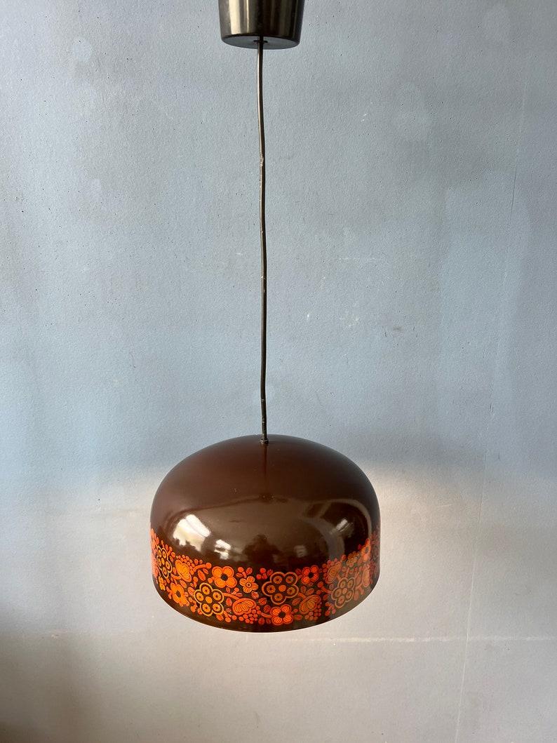 Mid century Arabia pendant lamp by Kaj Franck for Fog and Mørup. The lamp has a brown and orange enamel layer and is made out of thick metal. It has a playful decorative flower pattern. The lamp requires one E27/26 lightbulb.

Additional