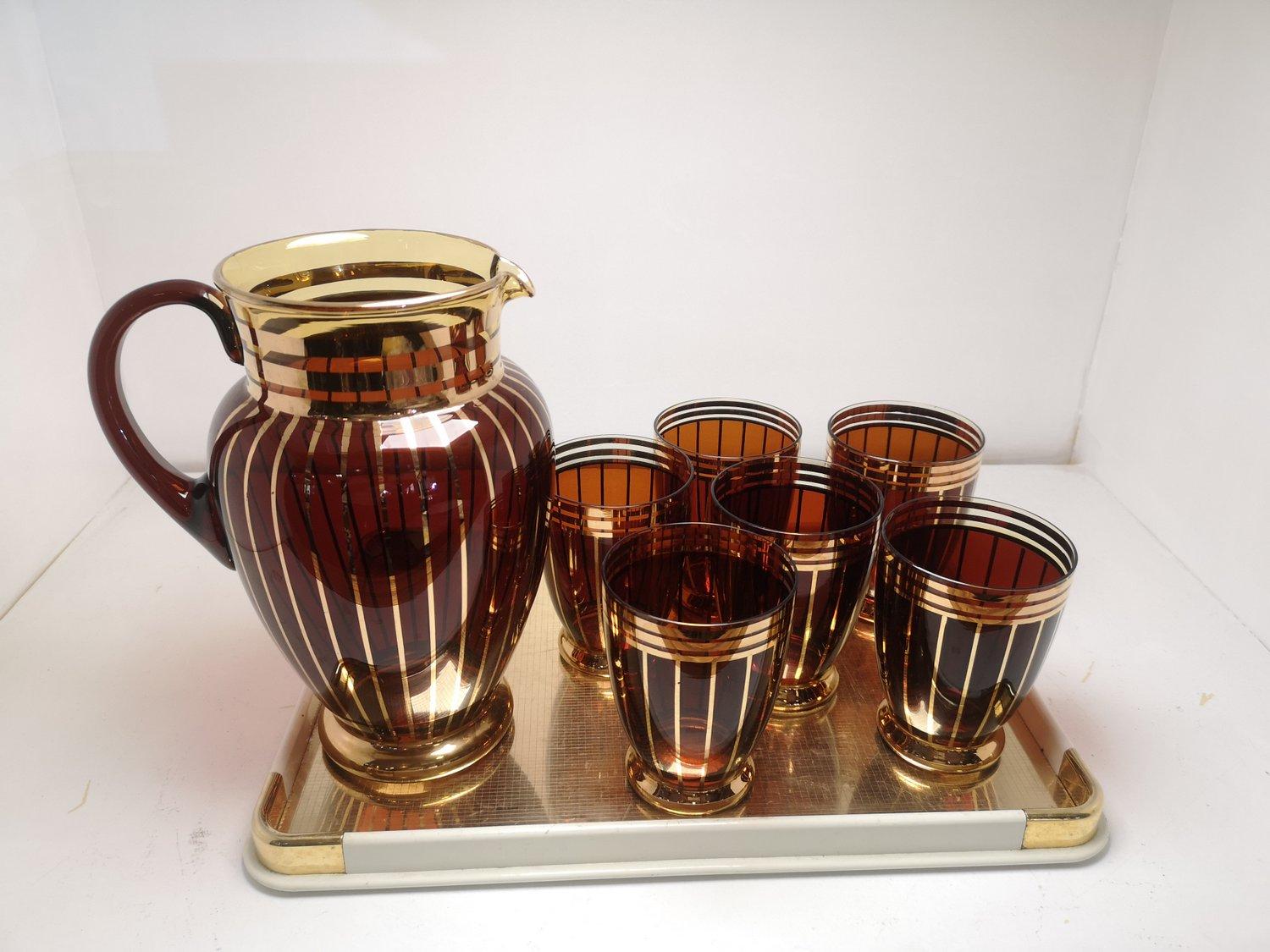 Special serving set with brown glass lemonade pitcher and 6 glasses,
gilded decor from the 1960s. This set is in perfect, beautiful condition. An excellent gift for garden parties.
Dimensions:
Tray: Width: 35cm, Depth: 25cm, Height: 3cm
Pitcher: