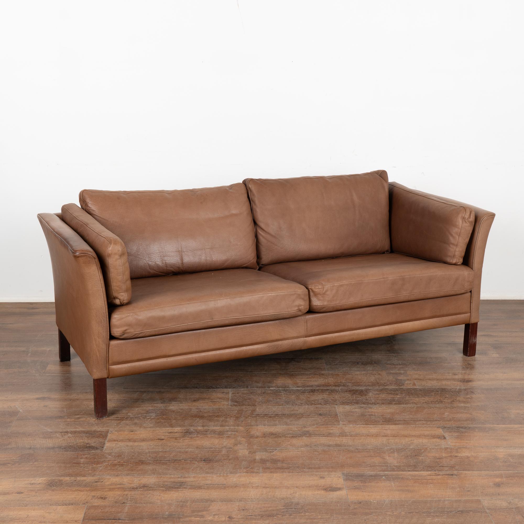Mid-century modern two seat leather sofa loveseat by Mogens Hansen. This is a comfortable sofa combining tradition and modern style.
Upholstered in vintage brown leather, loose cushions with down filling, hardwood legs in dark stained beech wood.