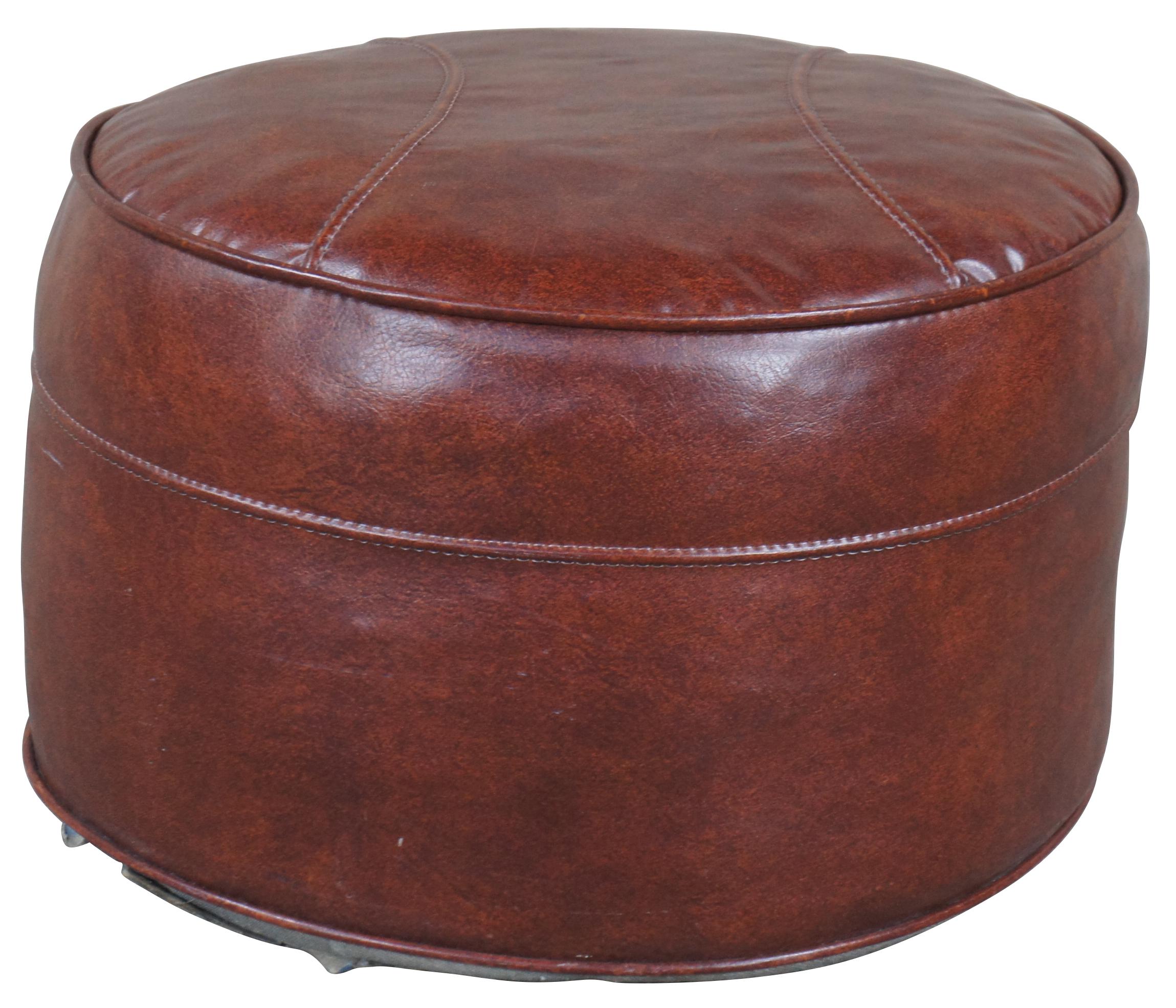 Mid Century Brown Vinyl Ottoman or Pouf. Features a squat round form with baseball shaped stitch.
