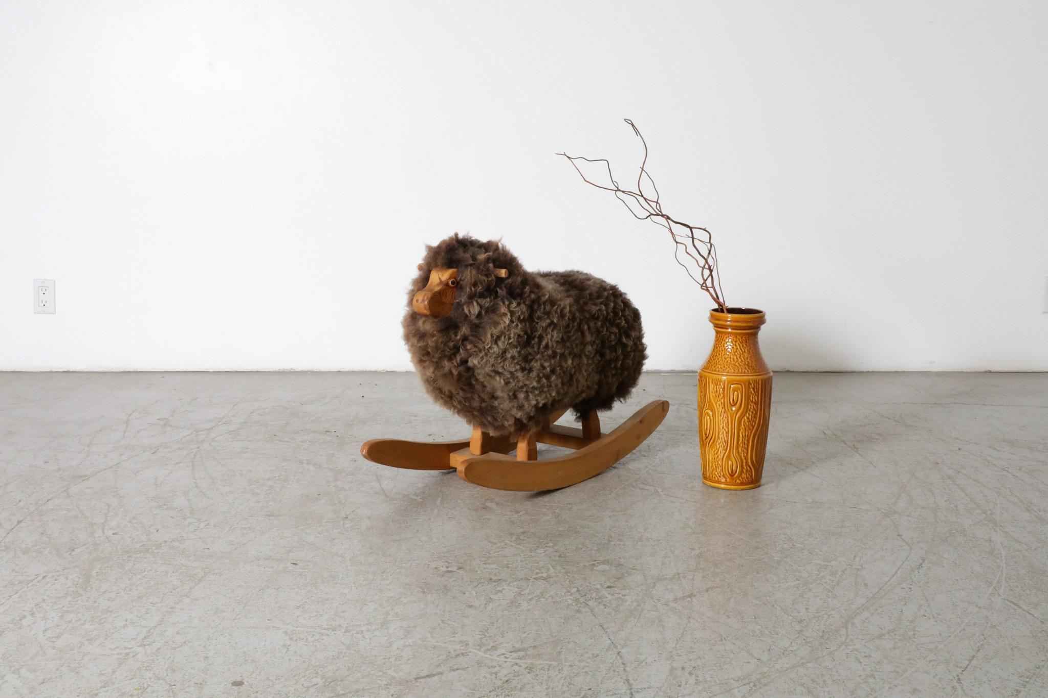 Cute mid-century rocking sheep with real sheep coat, carved wood face and rocker.  A vintage room accessory perfect for adding a little life and style to any room! In original condition with some visible wear consistent with age and light use. 