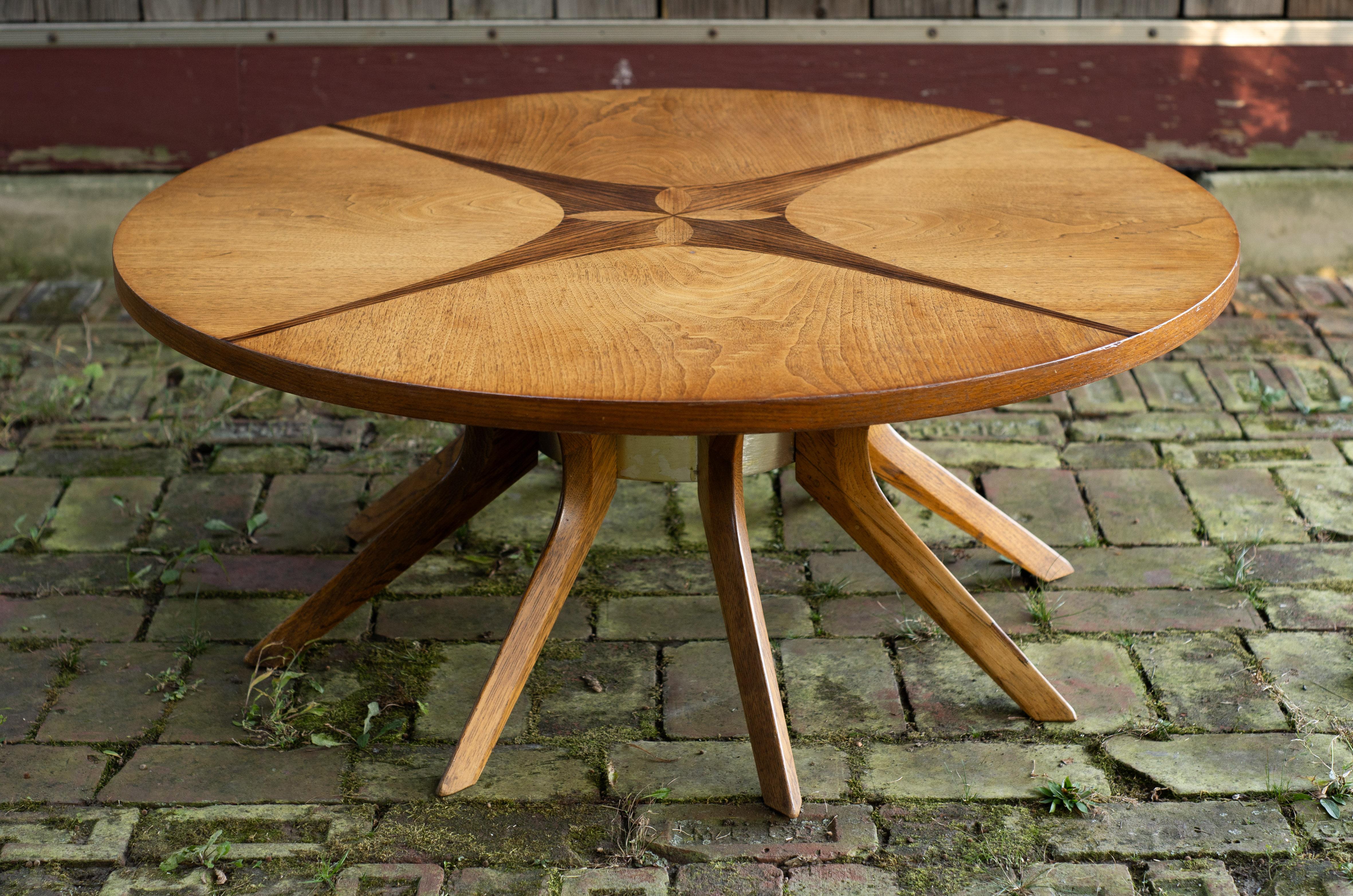 Dieser Tisch wurde von Broyhill in den 1970er Jahren für ihre Brasilia-Linie entworfen und ist möglicherweise das radikalste Design unter ihnen. Die runde 40-Zoll-Platte ist an allen vier Ecken mit Intarsien aus Nussbaum und Streifen aus Palisander