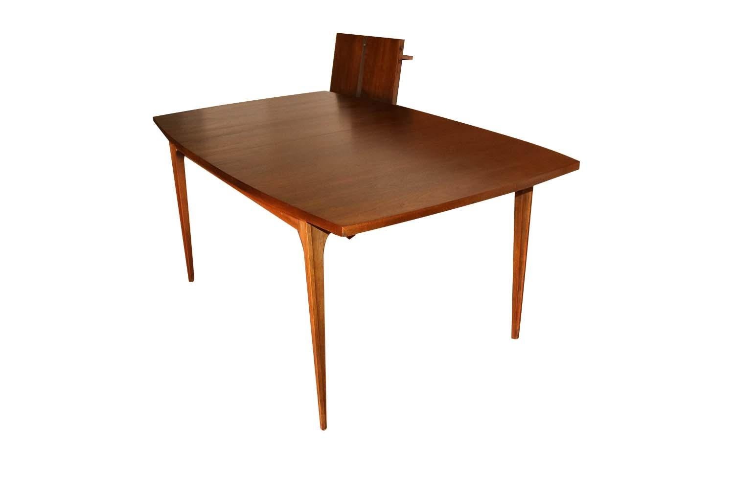 Stunning vintage Mid-Century Modern Broyhill Brasilia walnut dining table, circa early 1960s. This absolute jewel remains in nearly pristine condition throughout. The Brasilia line is a collection that was first presented at the world’s fair in