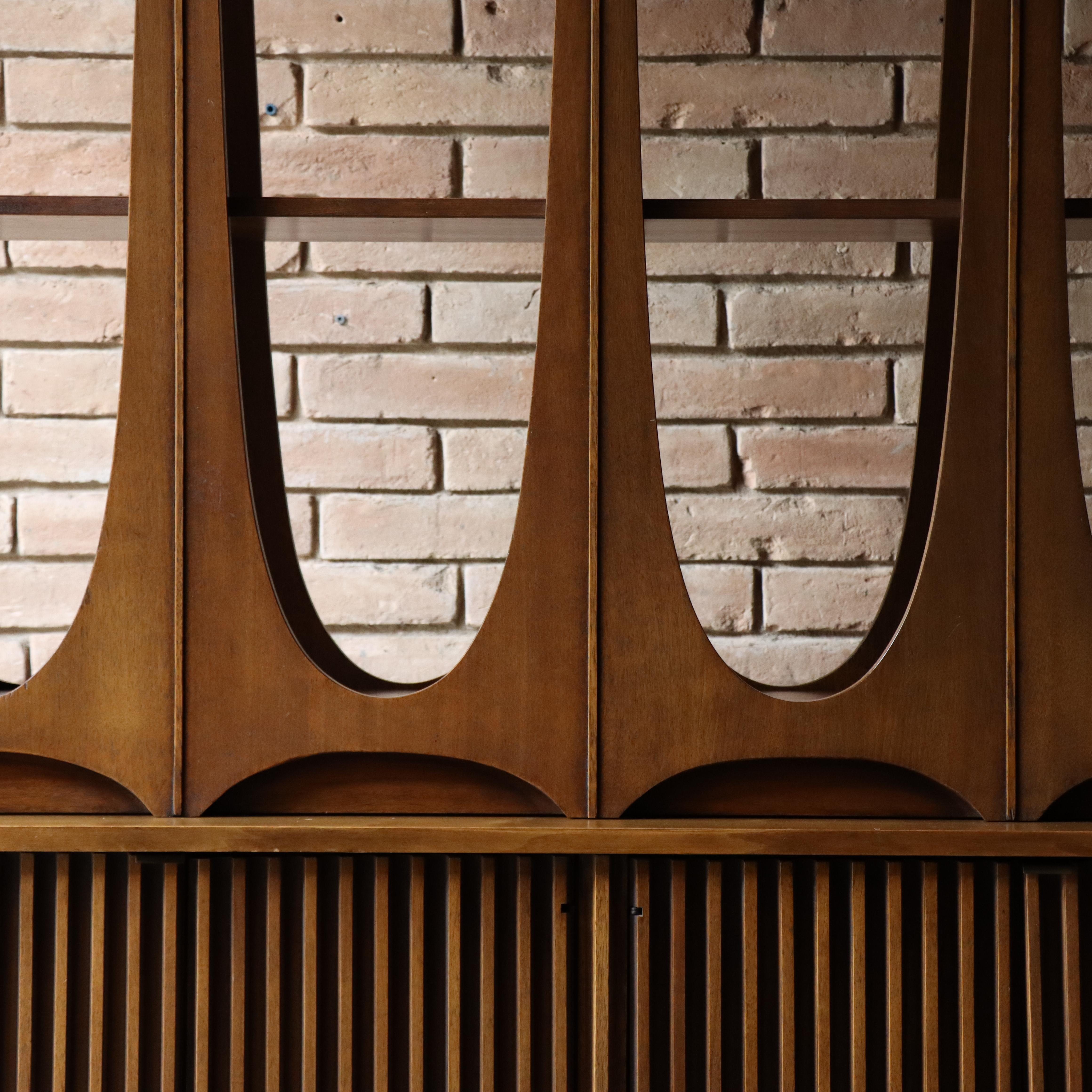 An iconic piece of mid-century design: the Broyhill Brasilia room divider. Crafted from rich walnut, this divider exudes timeless elegance. Its sleek lines and distinctive silhouette pay homage to the iconic Brasilia architecture, adding a touch of