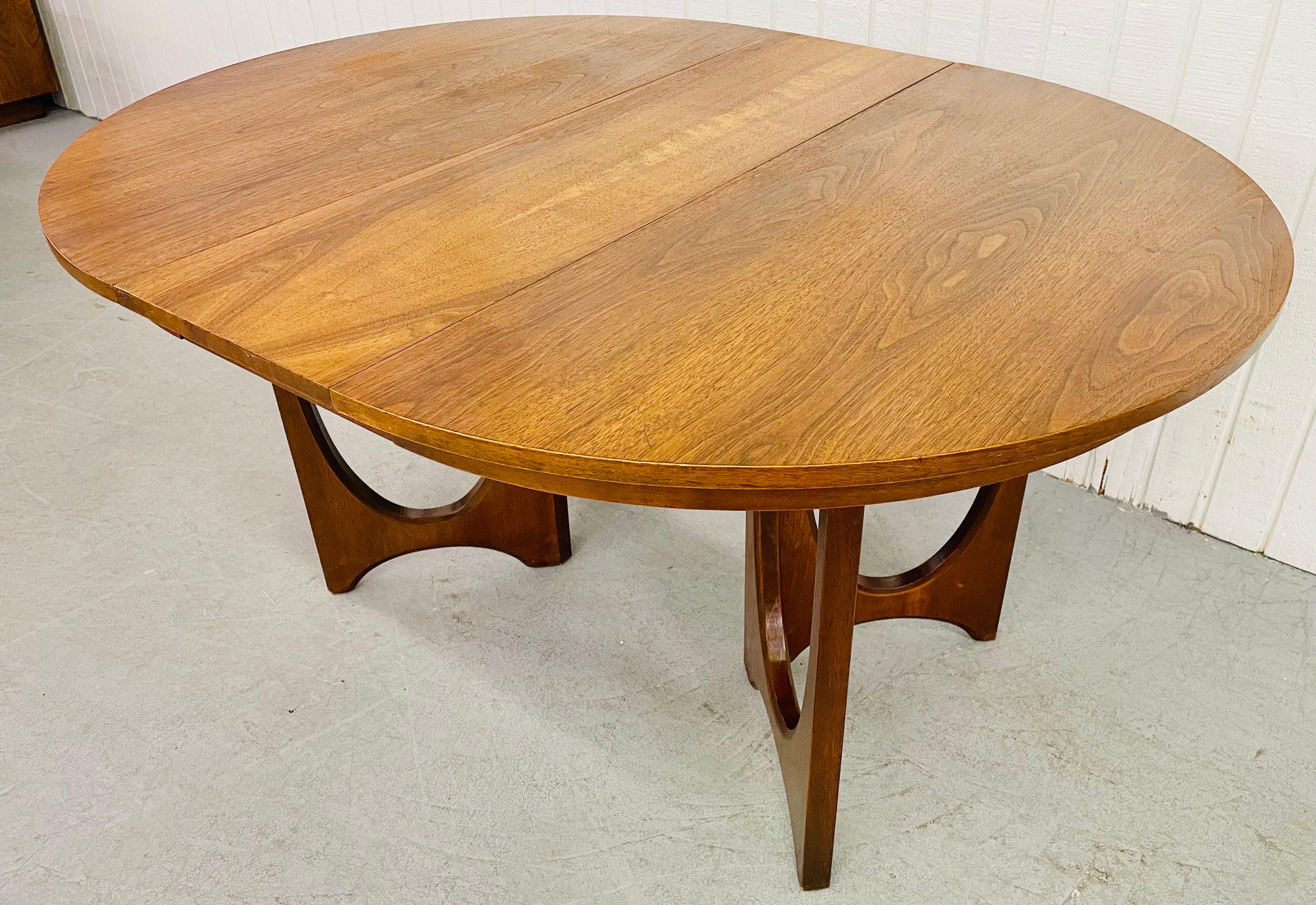 This listing is for a Mid-Century Broyhill Brasilia walnut dining table. Featuring the iconic walnut curved legs, round walnut top, one leaf that extends the table up to 56” L into an oval top, and a beautiful walnut finish.
