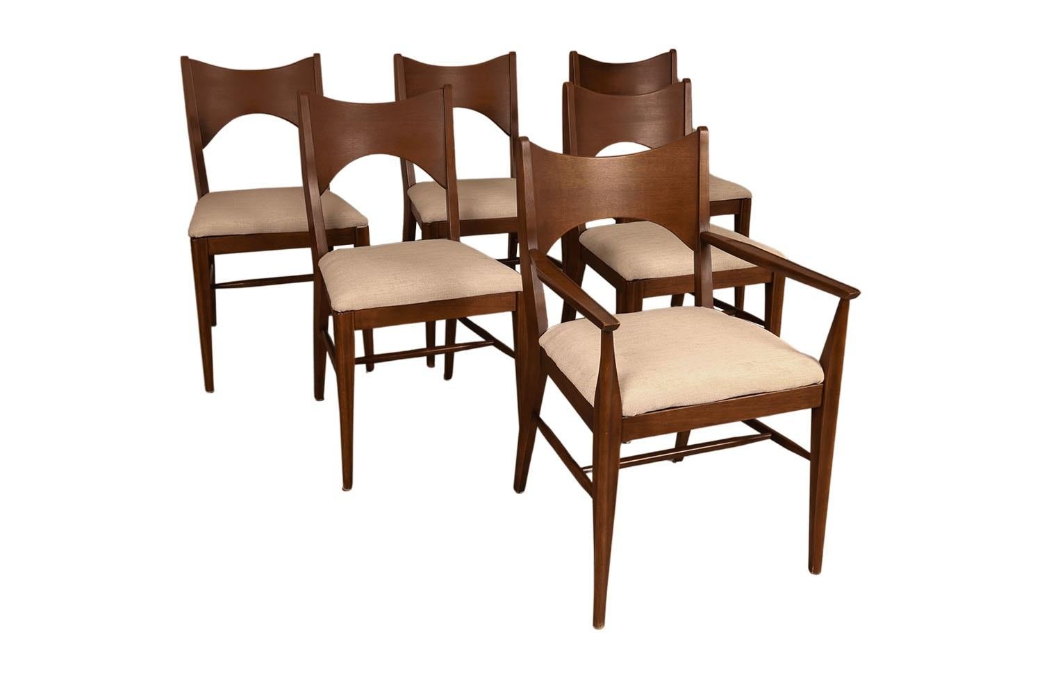 Set of six stunning Mid-Century Modern Walnut dining chairs from Broyhill Premier’s “Saga” collection, in the style of Paul McCobb. The walnut frames feature modern styling with a distinct beautiful design. Sculpturally carved bow-tie backrests with