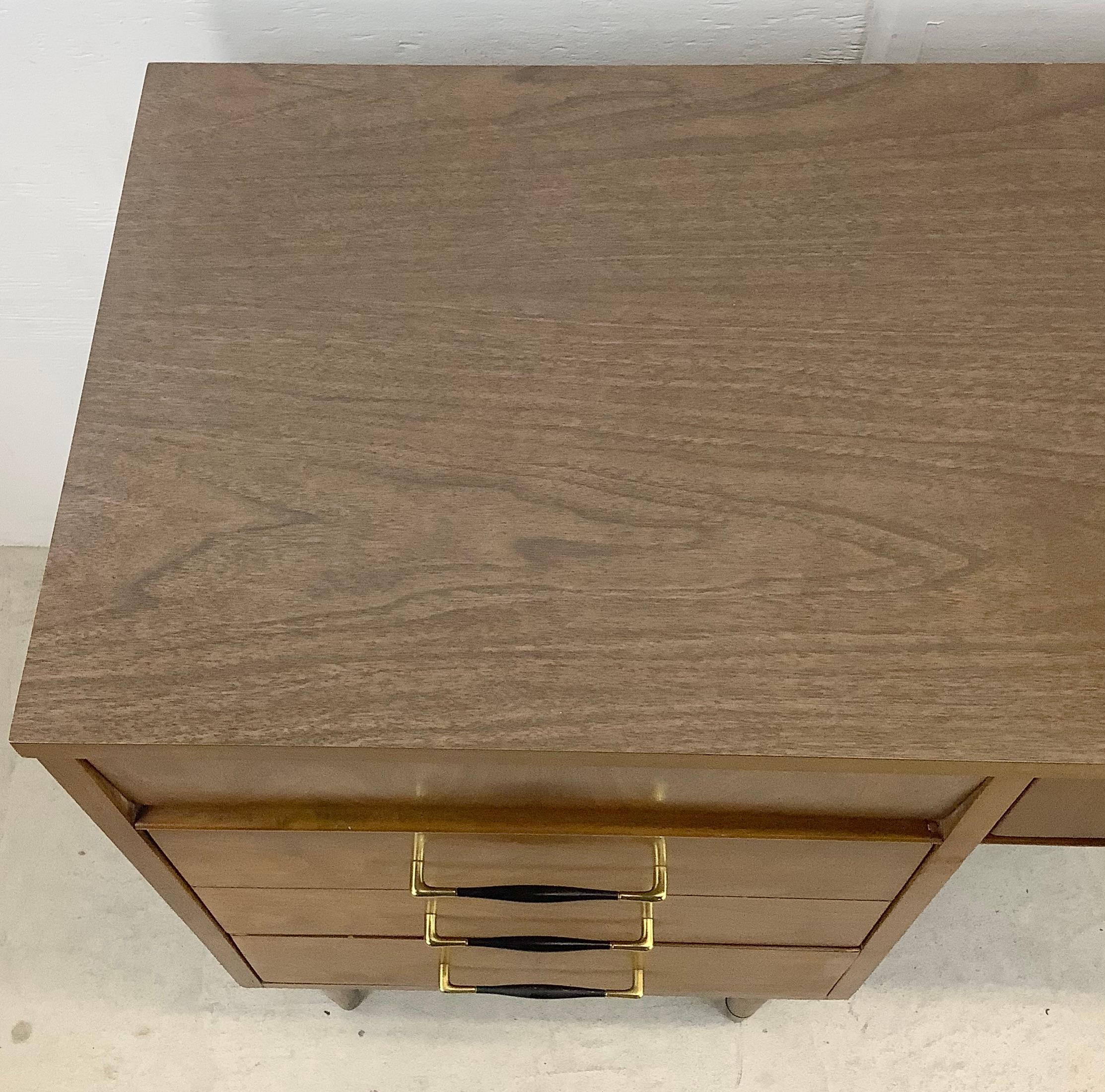 This petite writing desk offers just enough work and storage space to be the perfect fit for any room from office to bedroom. The vintage style of this mid-century piece includes a walnut finish, clean modern lines, and decorative painted metal