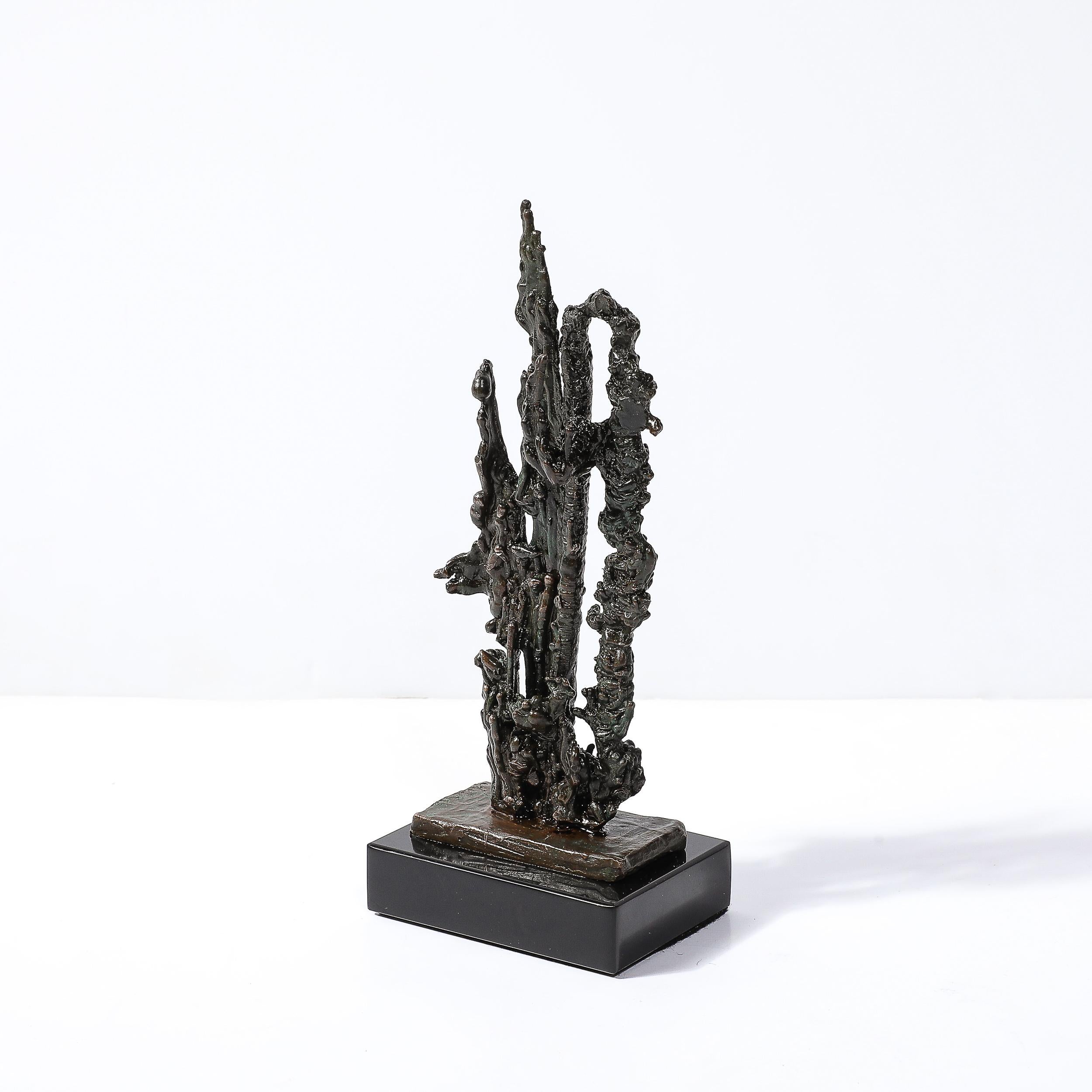 This remarkable Mid-Century Brutalist abstract sculpture, crafted by American artist Marion N. circa 1966, is a stunning representation of organic forms brought to life through the medium of bronze. The sculpture, with its intricate and textured