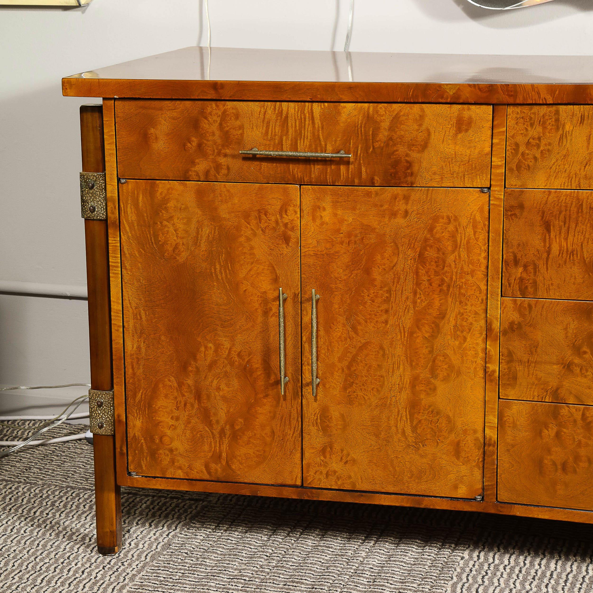 This stunning Mid-Century Modern sideboard was designed by the illustrious Harold Schwartz and realized by the Romweber Furniture Company in the United States, circa 1950. It features a volumetric rectangular body in a caramel hued walnut with a