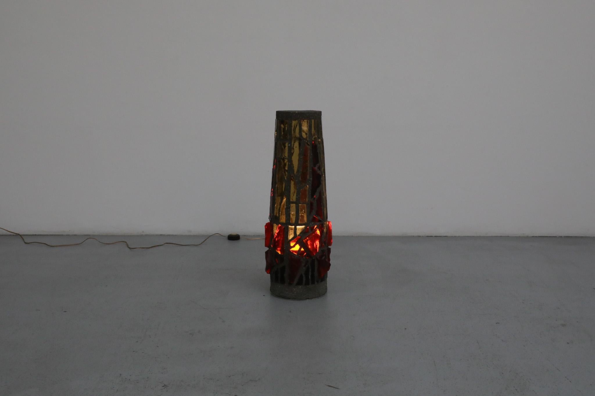 Spectaculaire lampadaire brutaliste en béton et mosaïque de verre. Provenant probablement d'une église allemande, cette œuvre d'art présente des tessons et des morceaux de vitrail rouge-orange et neutre encastrés dans du béton. La lumière traverse