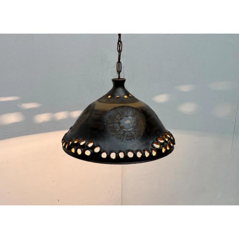 Lampada a sospensione in ceramica da studio brutalista di Bjørn Keramik, Danimarca.

Questa imponente lampada in ceramica colpisce per il suo stile scandinavo. Il paralume a imbuto presenta ornamenti tradizionali. Tutto intorno sono disposti motivi