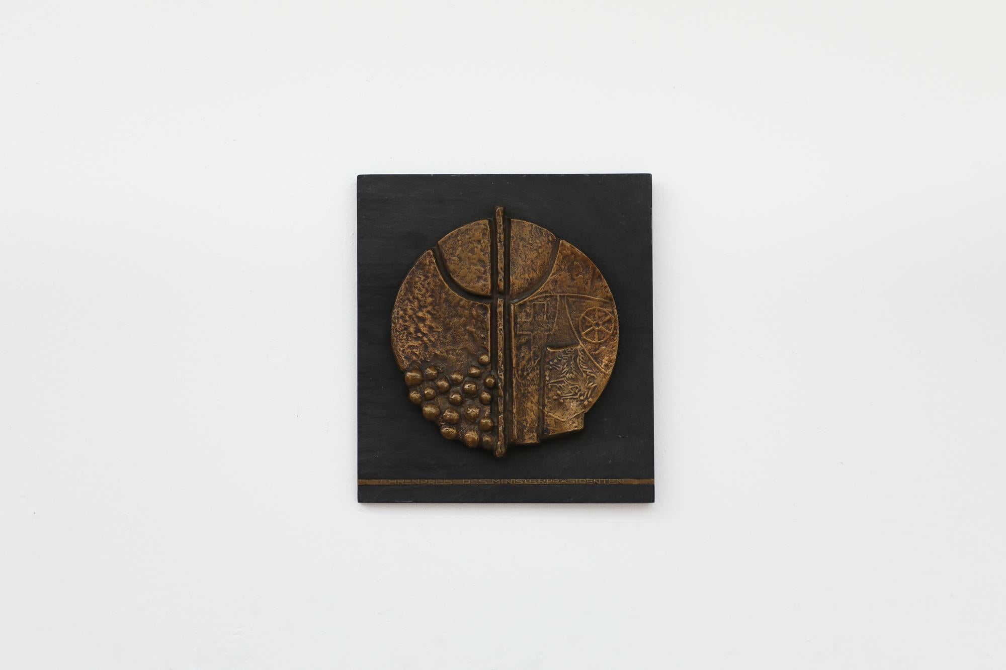 Hans Michael Kissel designed plaque to be given out as an honorary award by the prime minister of Germany. Mid to late 1970's. Beautifully cast, decorative, brass sculptural disc mounted on a slate slab with inset brass commemorative insignia.