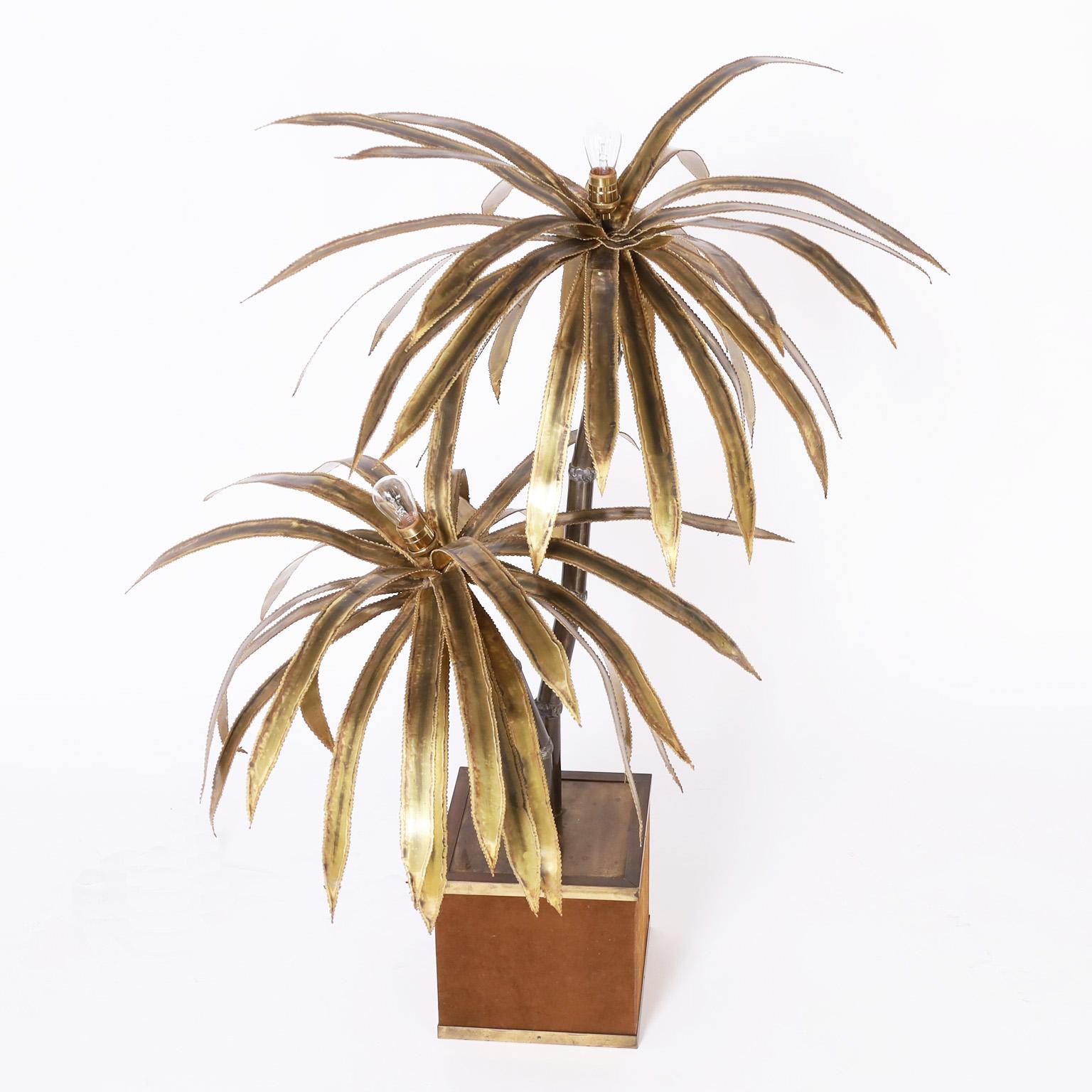 Striking mid-century palm tree sculpture with brutalist style leaves having lights at the tops on faux palm tree trunks in a square brass planter clad in brown velvet.